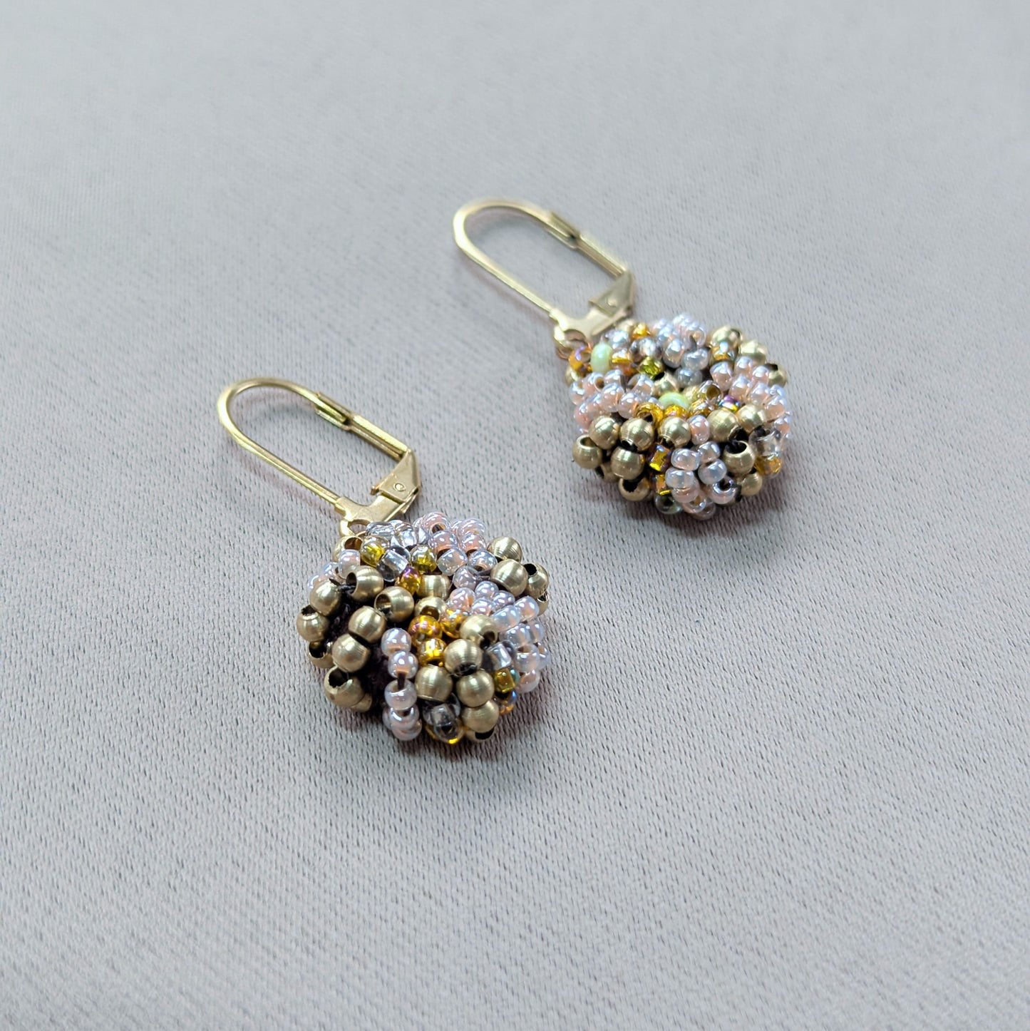 Close-up of solid brass and vintage glass seed bead earrings.