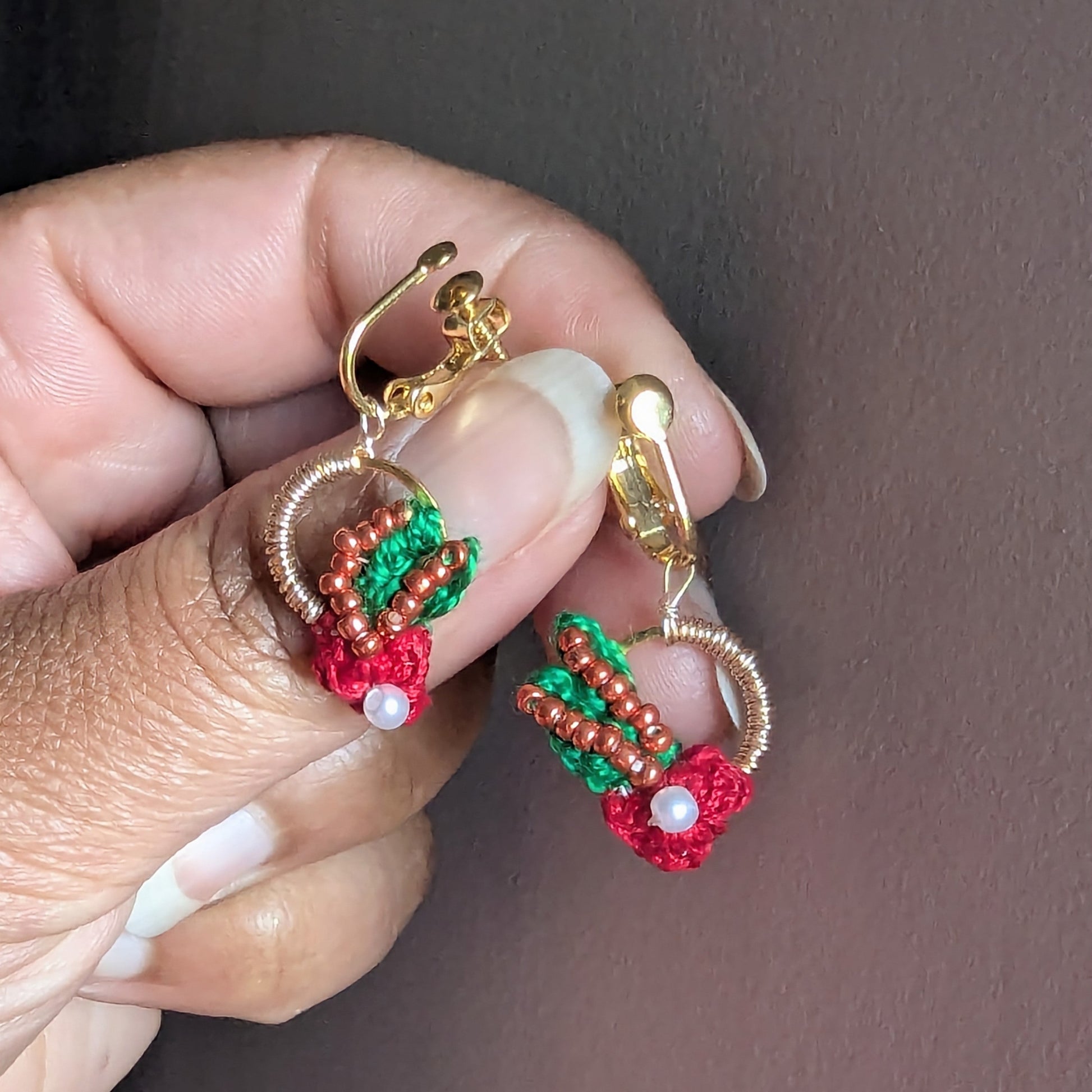 Hand held view of a dangle drop one-of-a-kind pair of Kumkum earrings handmade by Megha of Mayaani Jewellery for comfortable heirloom quality clip-on earrings for women who love earrings but have no piercings.