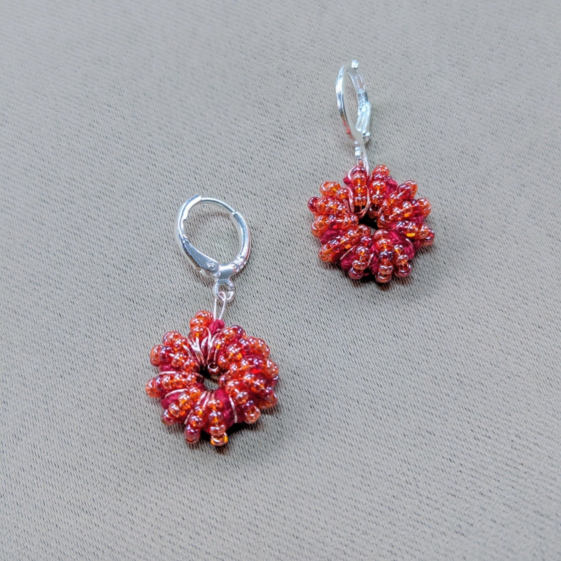 Masi Collection orange-red handmade earrings featuring rose gold wire and Egyptian cotton.