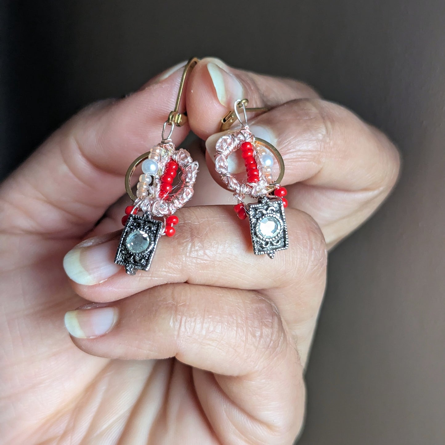 Close-up of Inara one-of-a-kind everyday beaded earrings with vintage cubic zirconia drop, blush wrap detail, glass seed beads and seed pearls on gold stainless steel hoops.