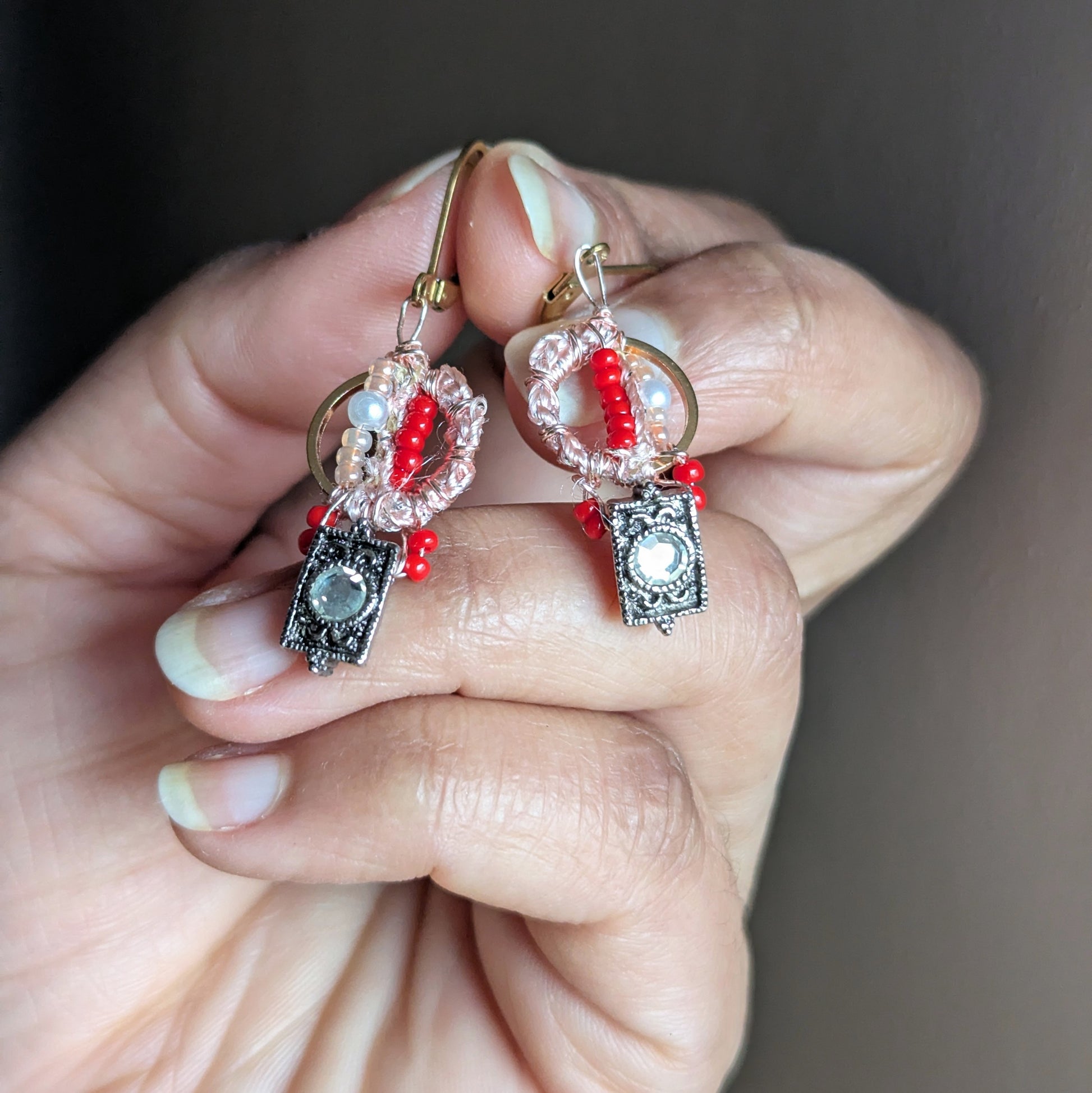 Close-up of Inara one-of-a-kind everyday beaded earrings with vintage cubic zirconia drop, blush wrap detail, glass seed beads and seed pearls on gold stainless steel hoops.
