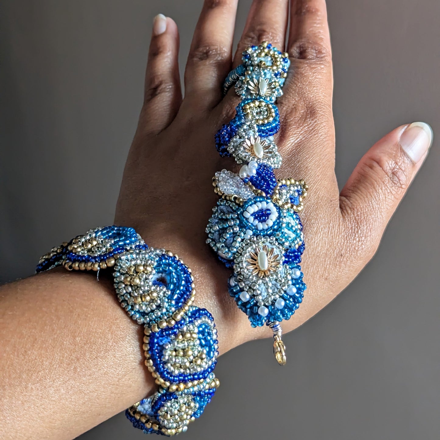 A close-up of a hand wearing the Nira 5-in-1 ornate beaded Indian hand bracelet showing how the piece separates.