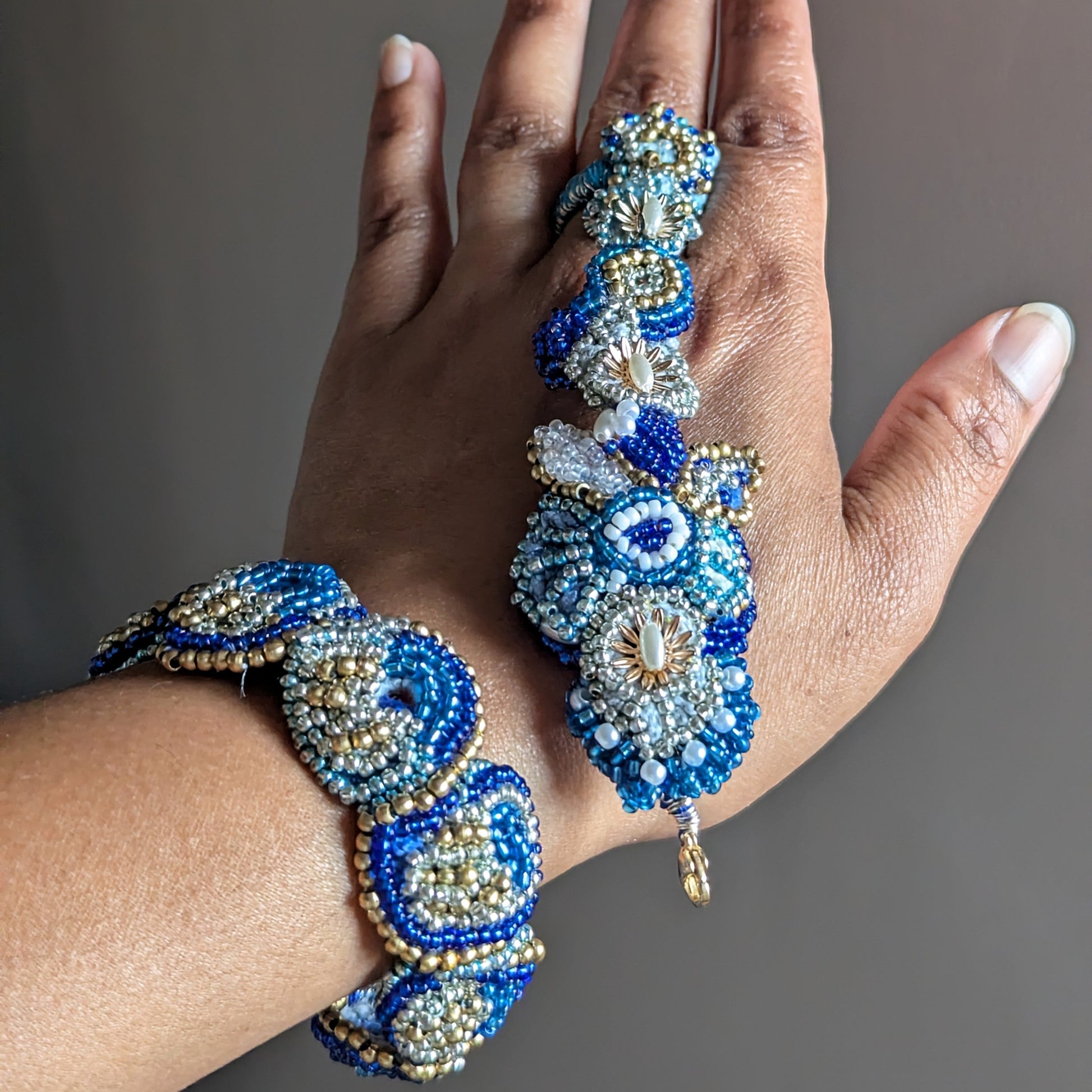 A close-up of a hand wearing the Nira 5-in-1 ornate beaded Indian hand bracelet showing how the piece separates.