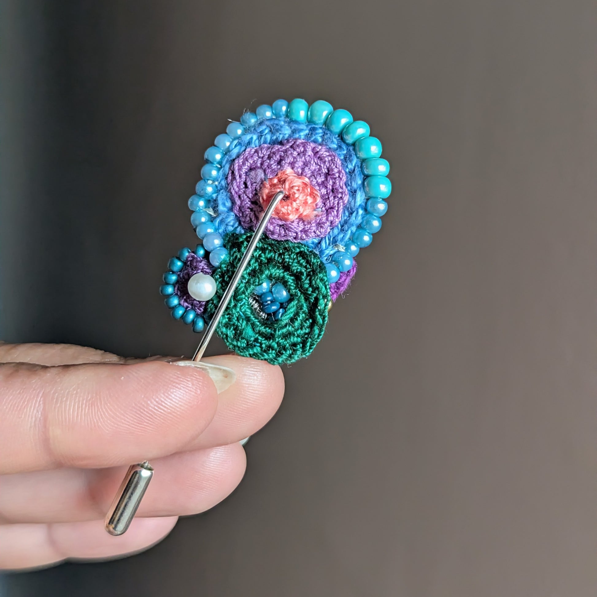 Back view of Kairavi brooch showing stainless steel pin fastening and crocheted backing.
