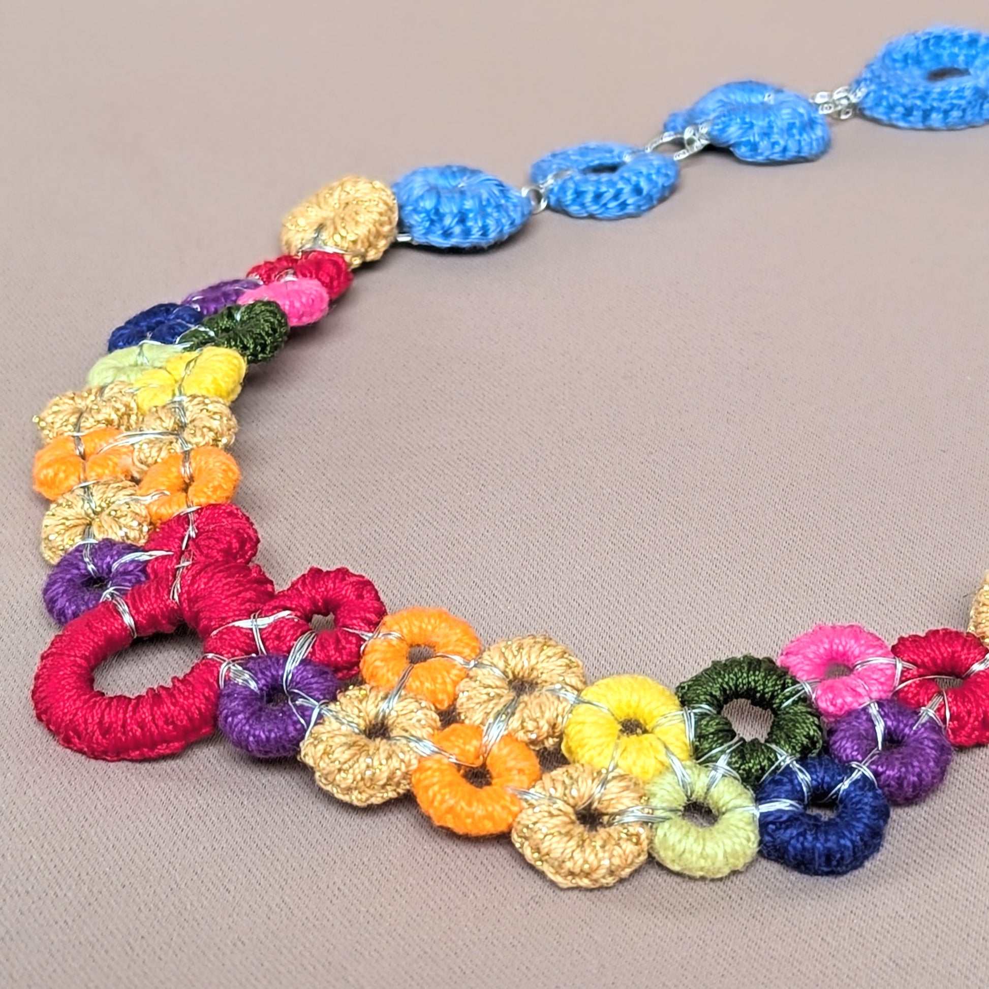 Handcrafted modular rainbow necklace with interchangeable chain options, showcasing colourful crochet silver wire centrepiece.