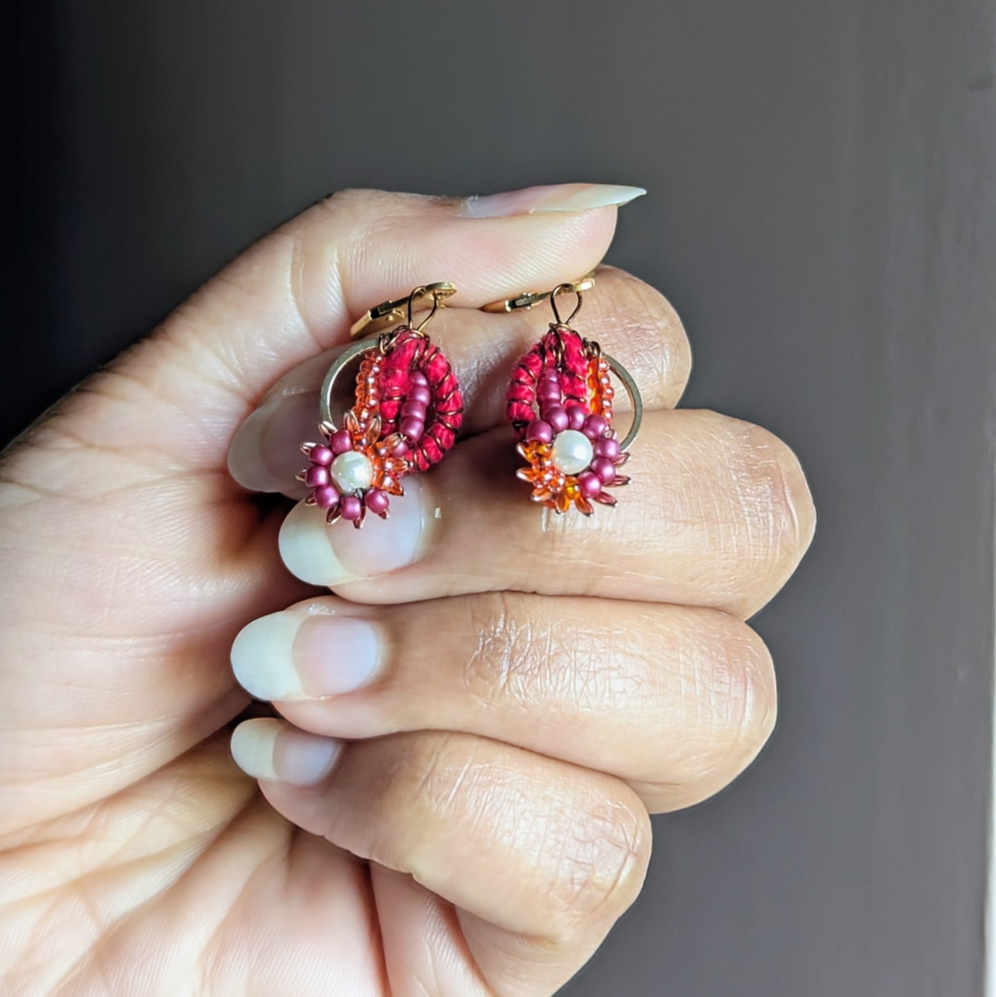 Lalima earrings featuring glass seed beads, gold hoops, and red pearl cotton crochet.