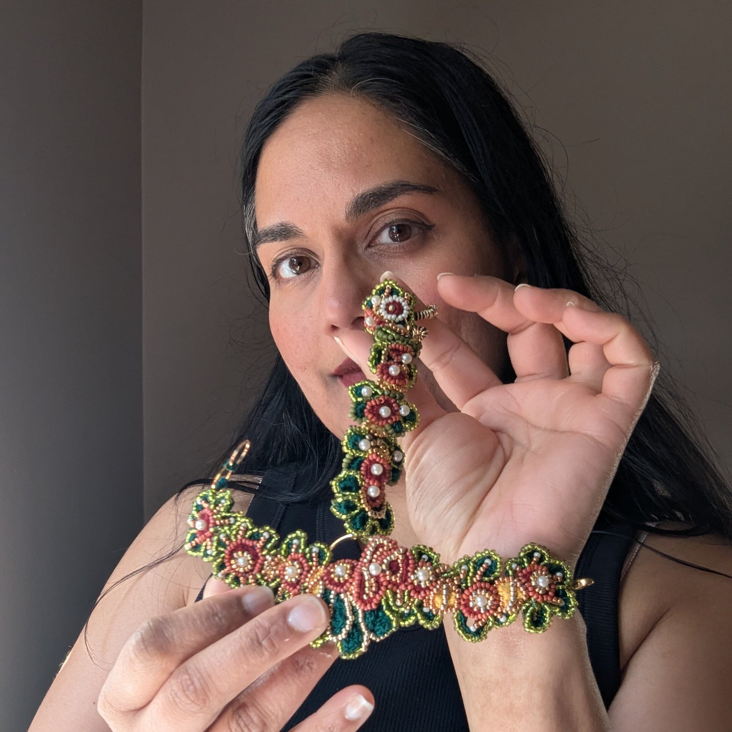 Indian designer and artisan Megha holding up the Mayaani Jewellery Rukmini 5-in-1 Indian hand bracelet designed to be worn five different ways.