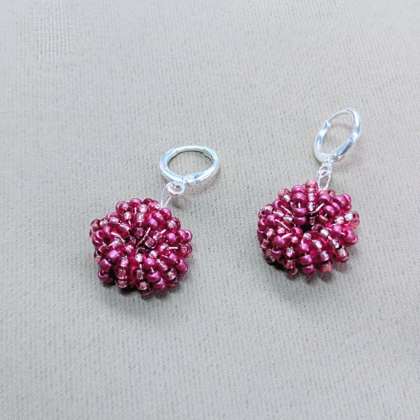 Pair of Masi Berry handcrafted earrings featuring luminous pink glass seed beads woven with Egyptian cotton.