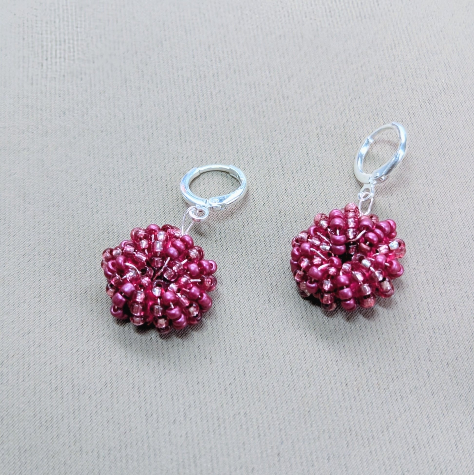 Pair of Masi Berry handcrafted earrings featuring luminous pink glass seed beads woven with Egyptian cotton.