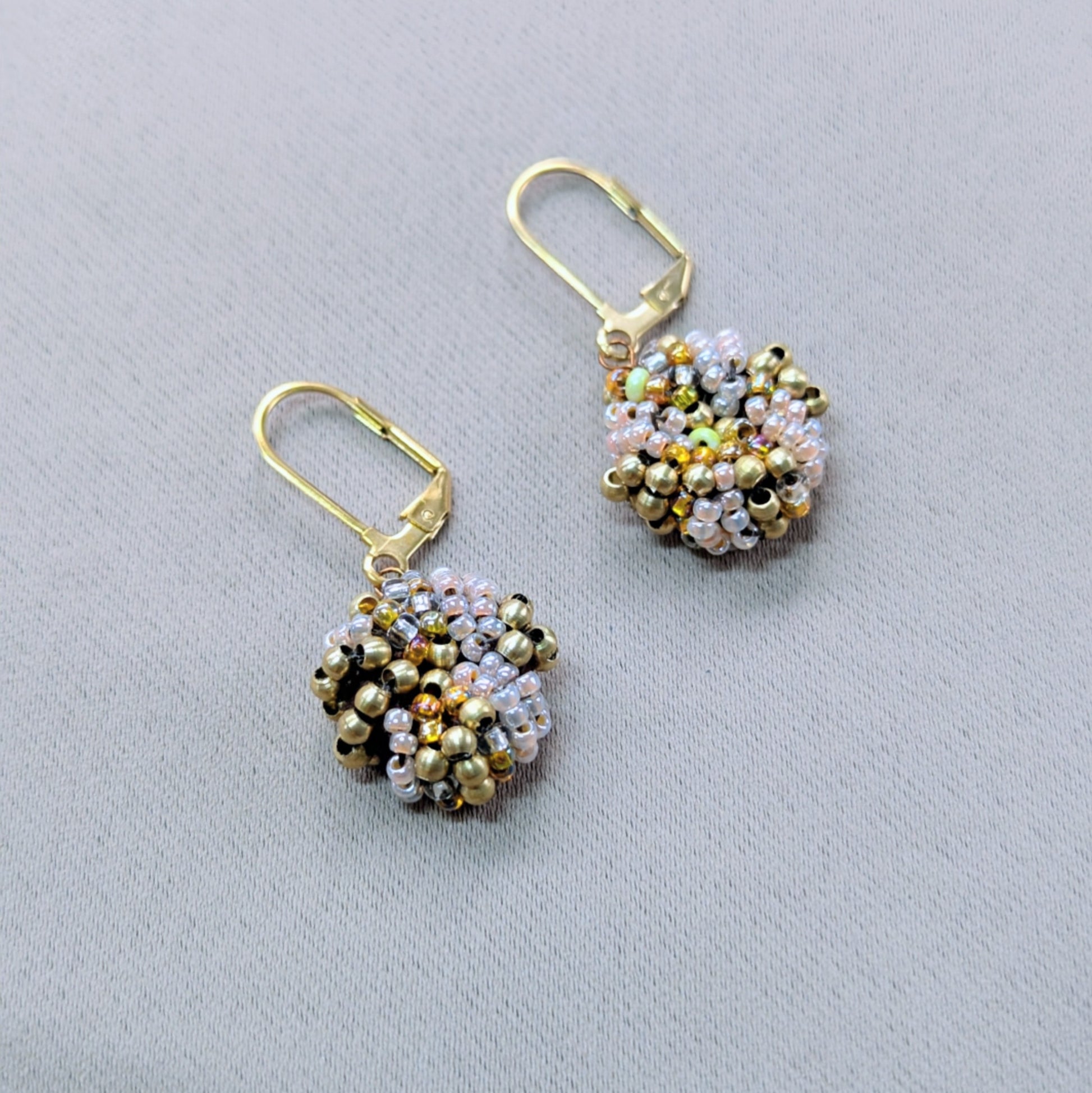 One-of-a-kind gold bead earrings symbolising wholeness and warmth.