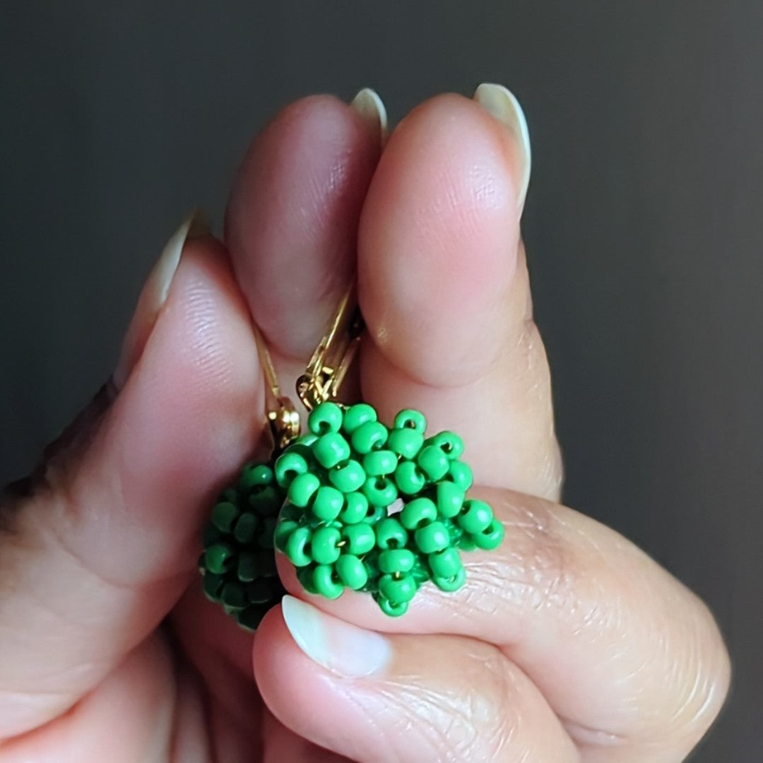 Close-up of one-of-a-kind handmade light green beaded earrings symbolising artisan craftsmanship and sustainable luxury.