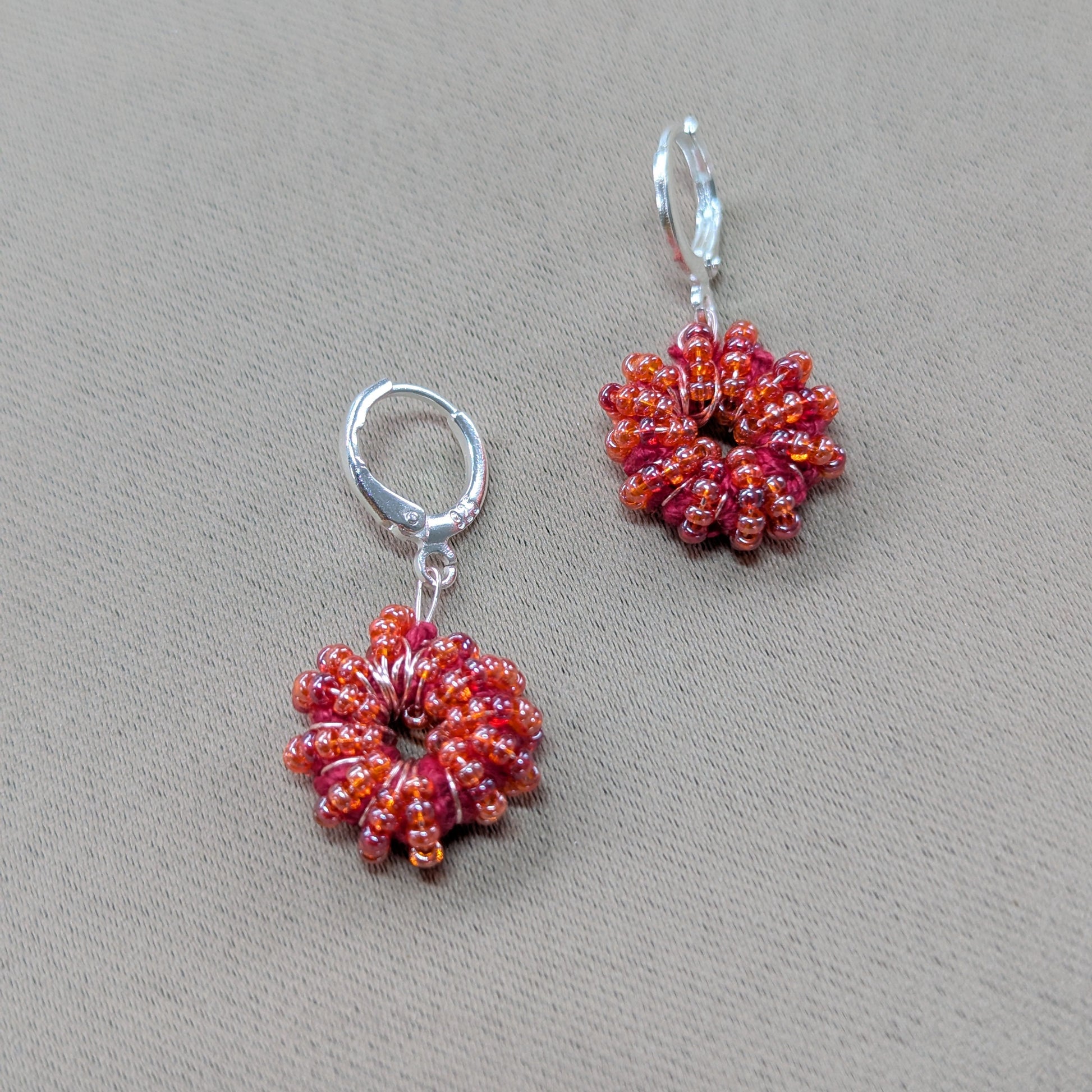 Artisan-crafted red-orange earrings designed by Indian jewellery designer Megha.