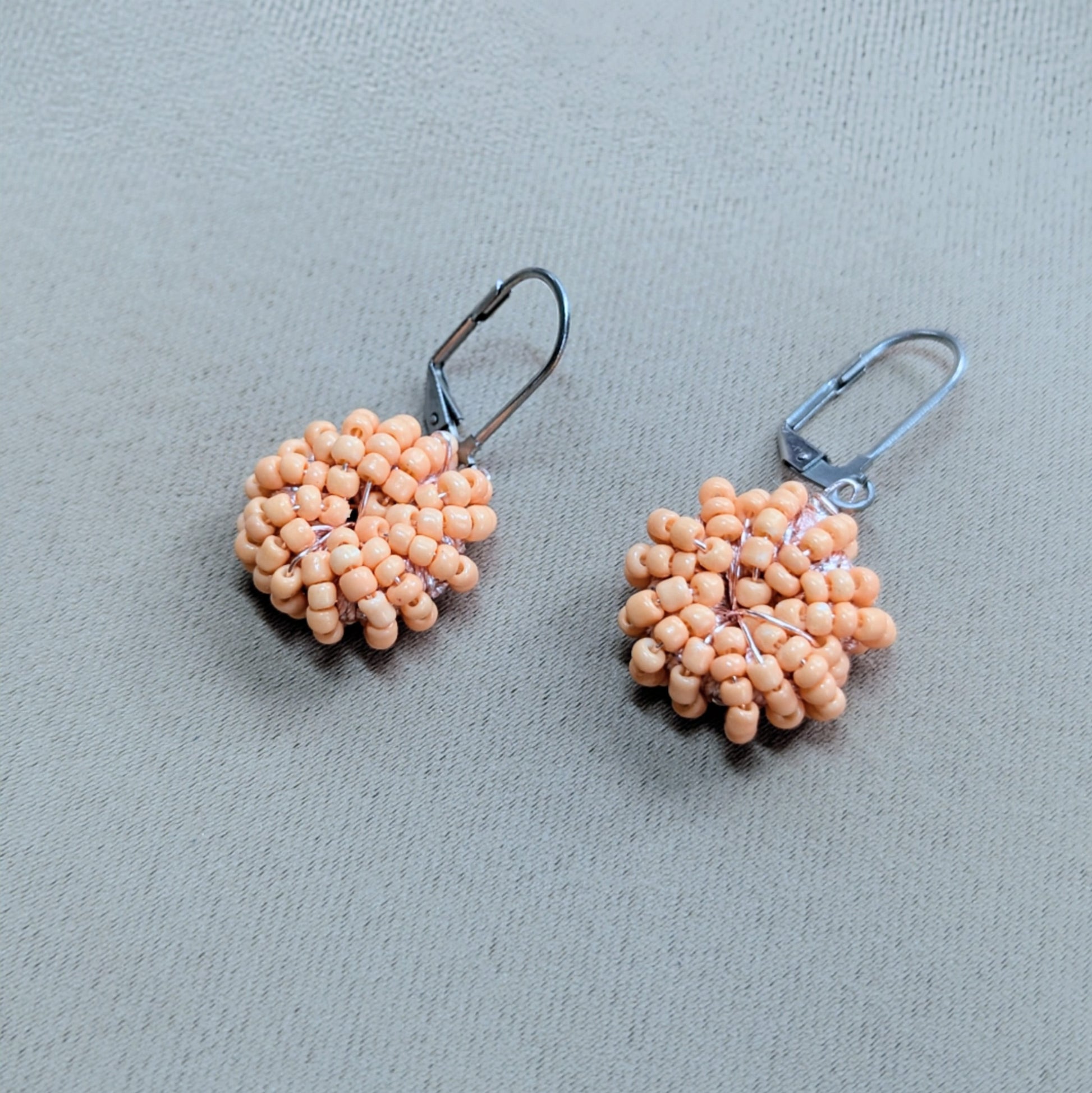 Handwoven peach bead earrings designed by Indian artisan Megha.