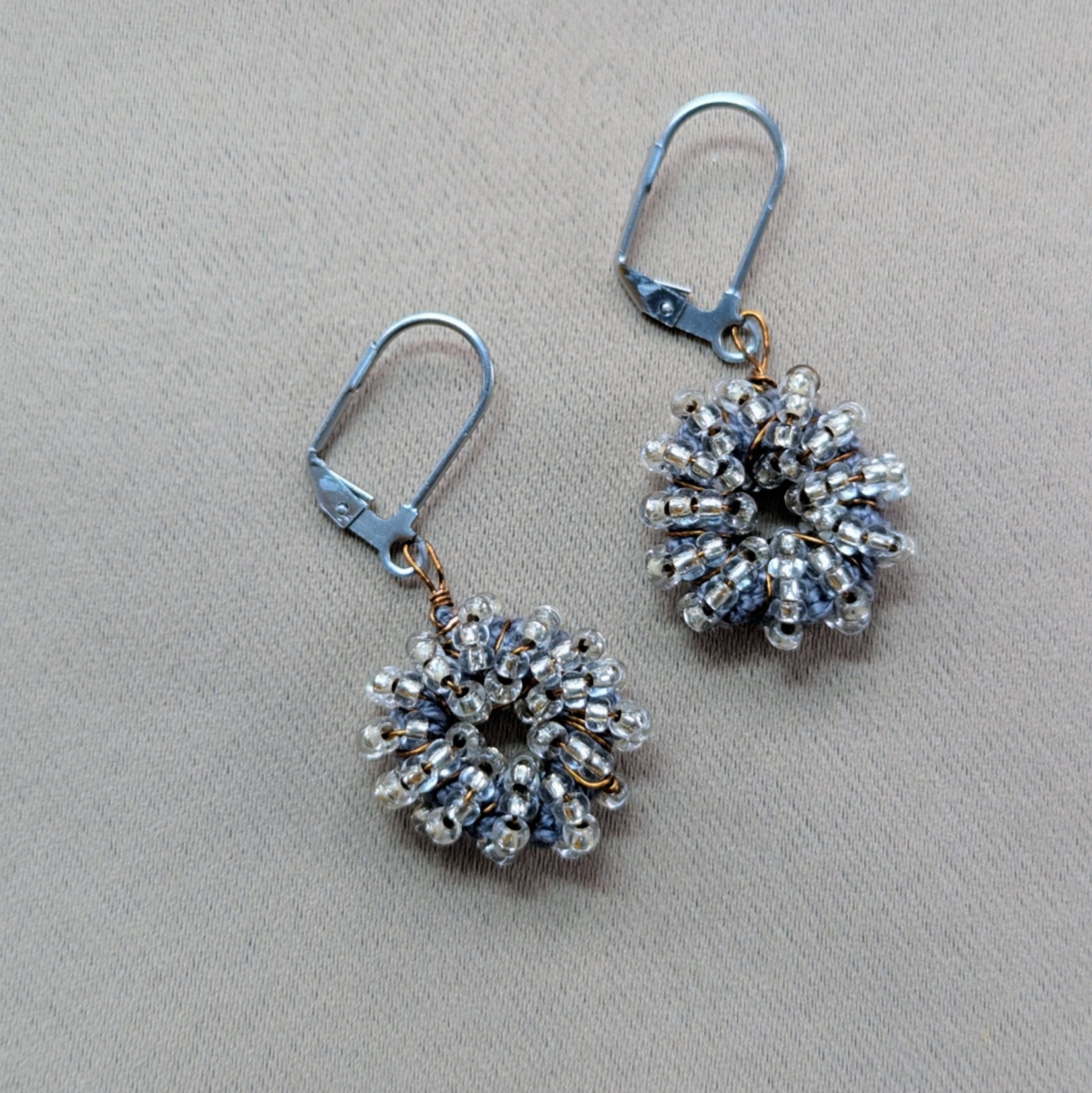 Indian artisan Megha’s handmade earrings featuring antique bronze wire and seed beads.