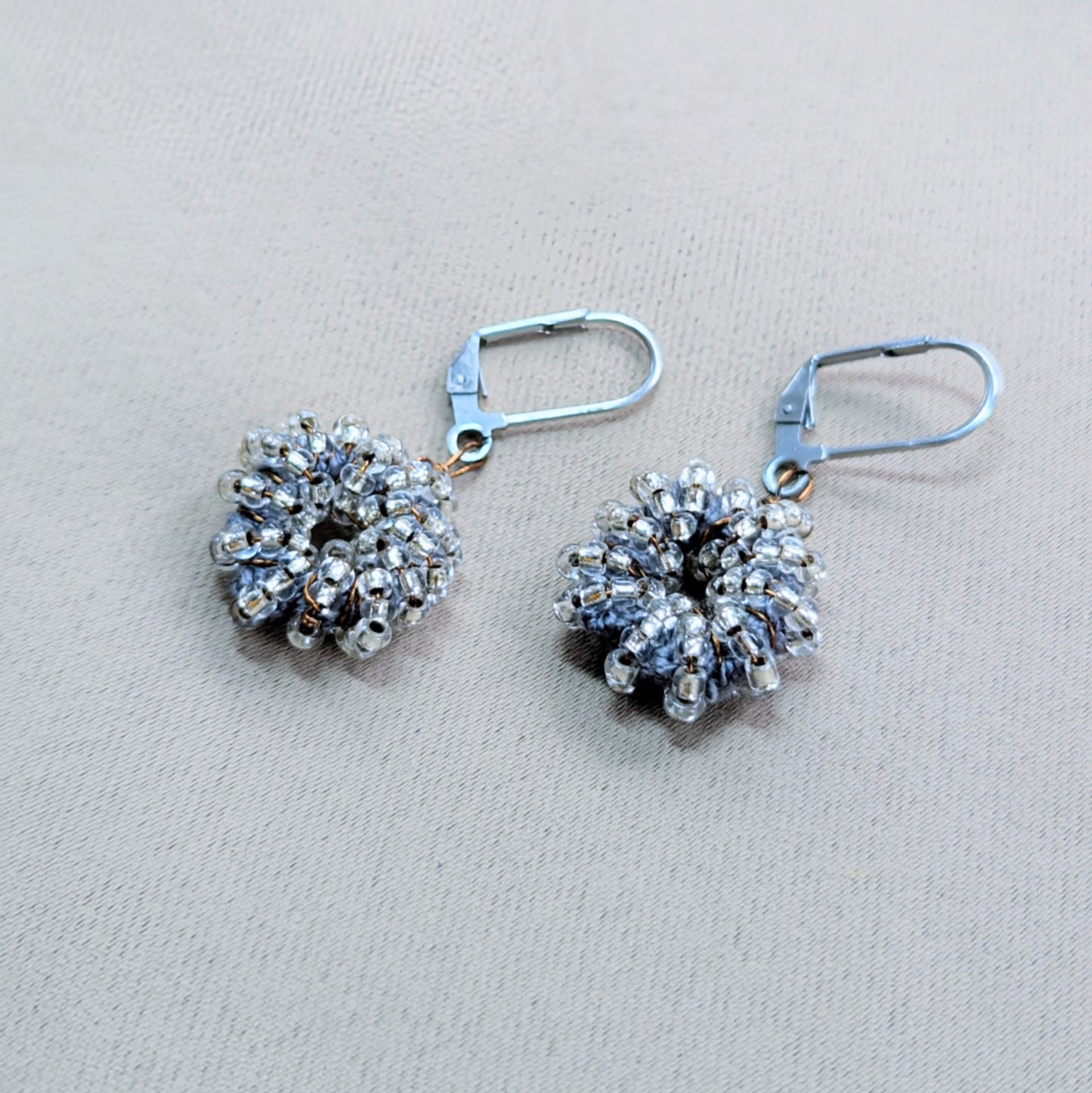 Sustainable handmade earrings with cool silver-blue hues and fine detail.