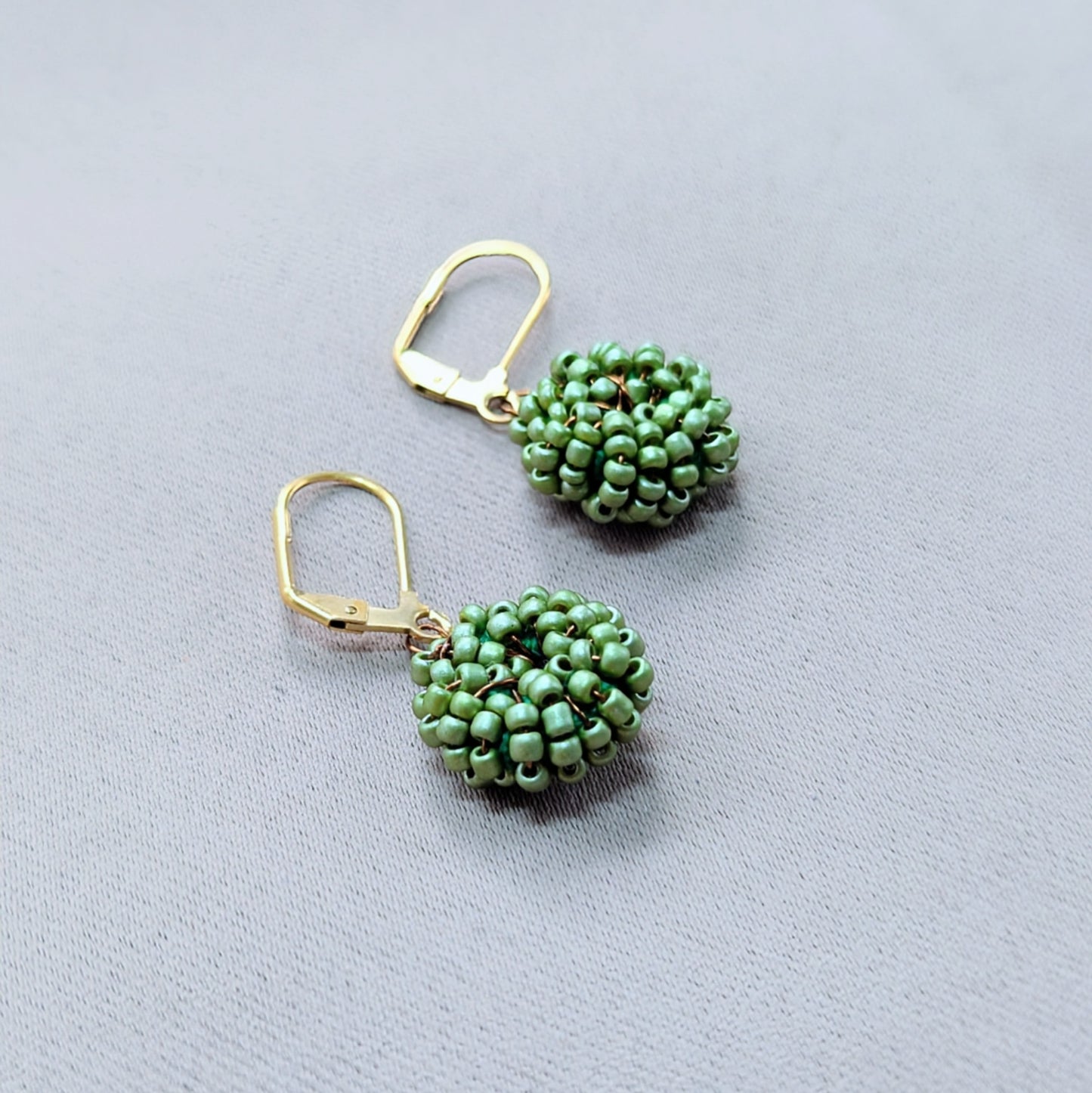 Sustainable soft green beaded earrings symbolising renewal and connection.