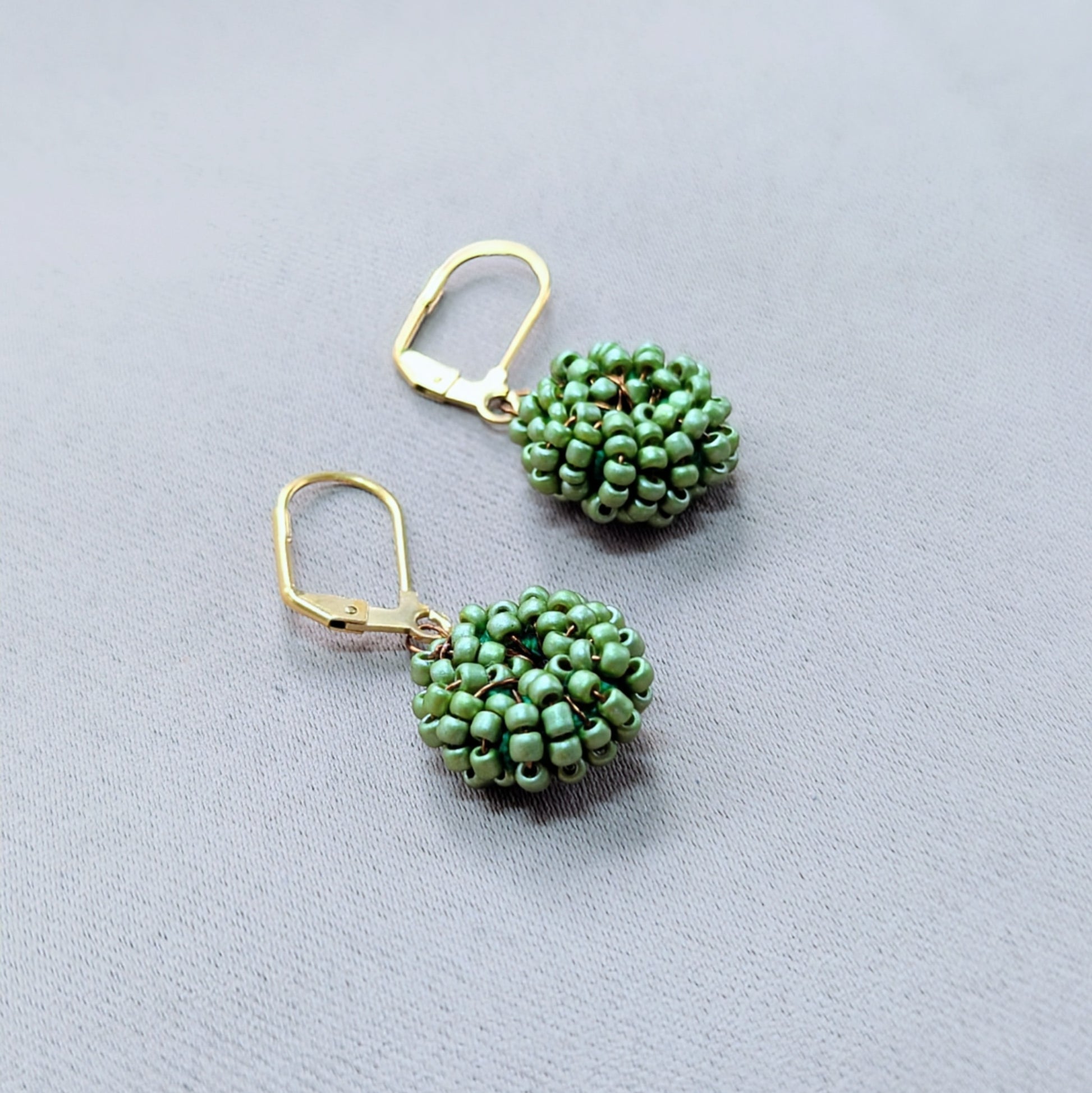 Sustainable soft green beaded earrings symbolising renewal and connection.