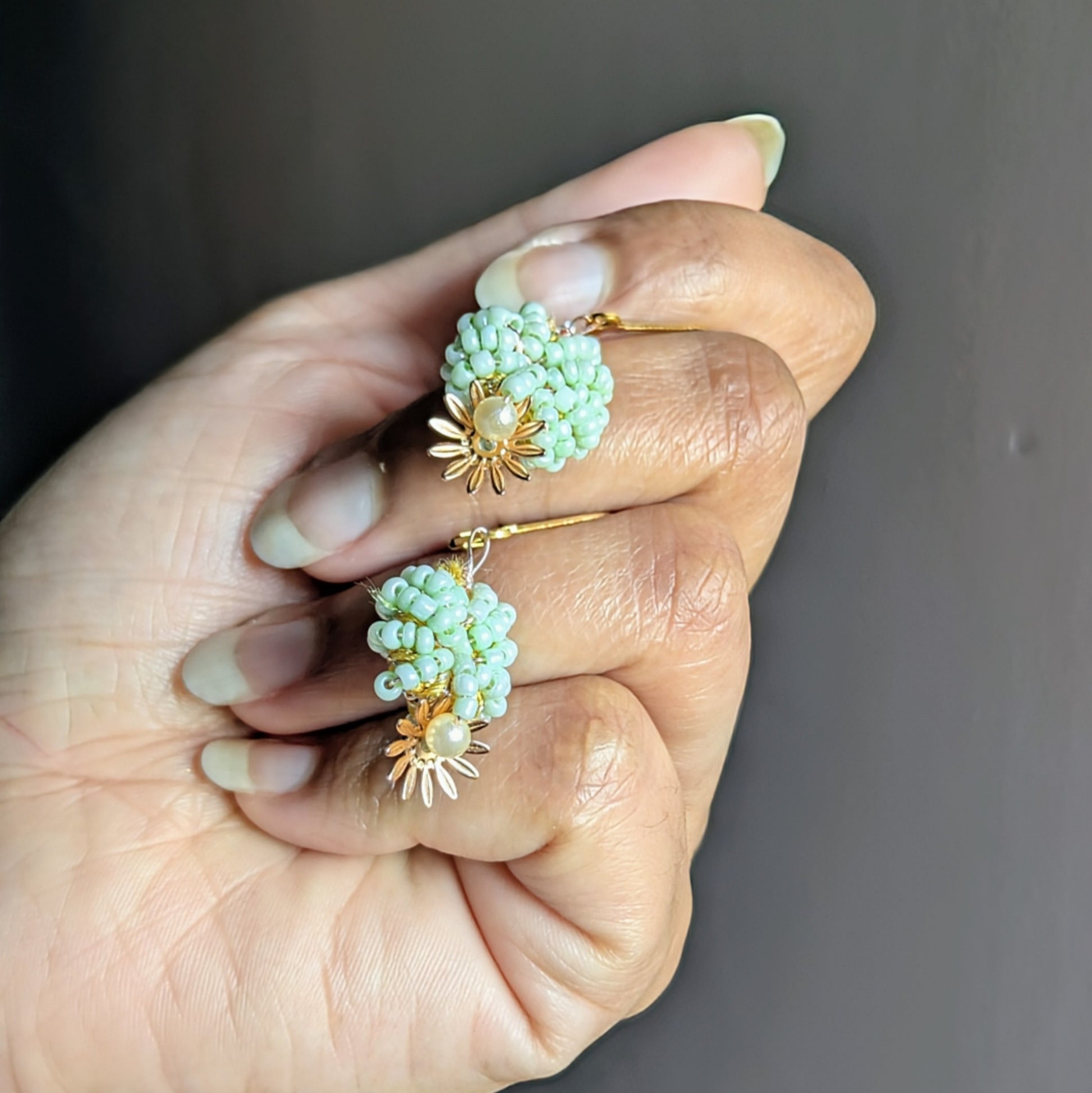 Close-up of mint green glass seed bead earrings with vintage upcycled seed pearls, handmade lightweight fine jewellery.