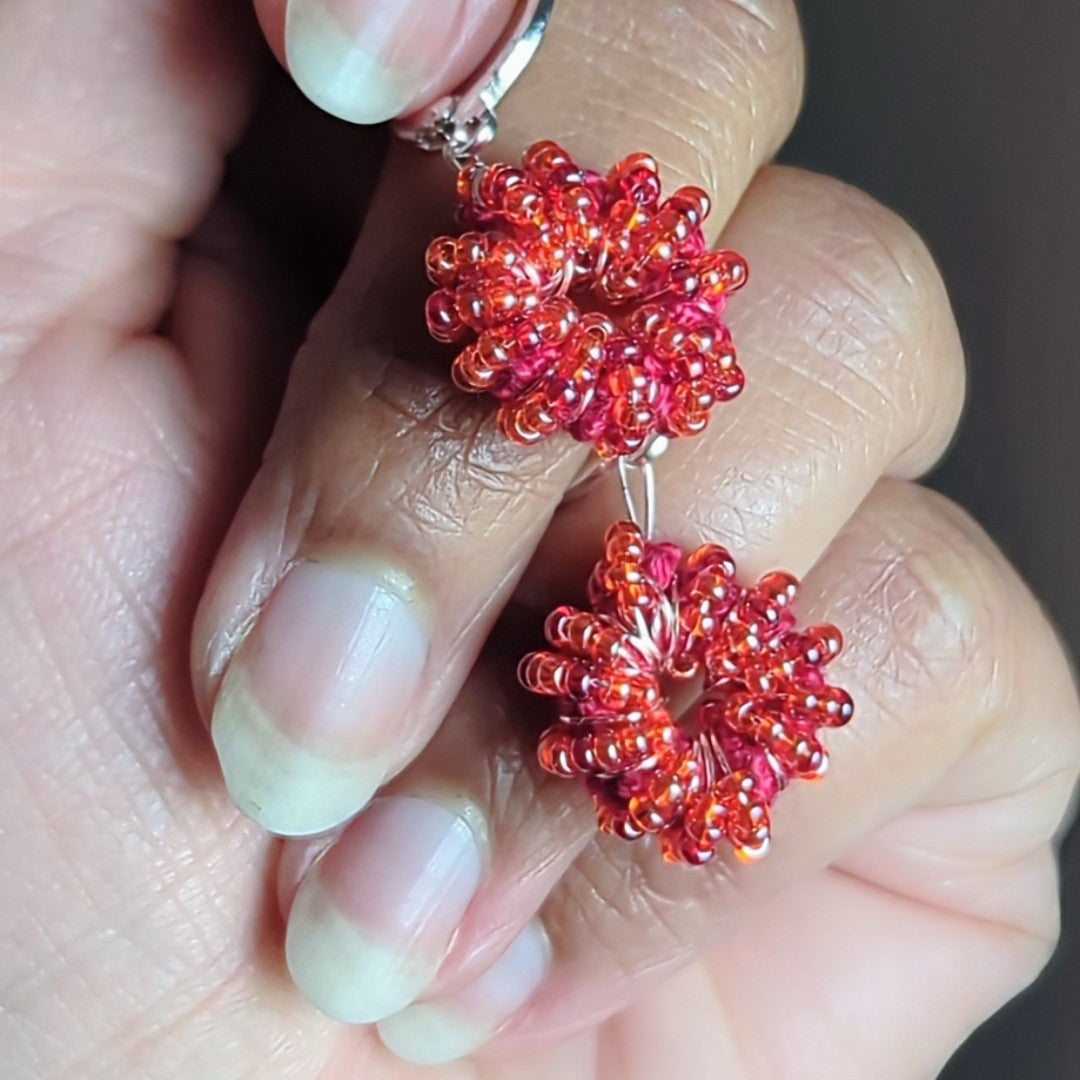 Bright red-orange hoop earrings inspired by family heritage and joy.
