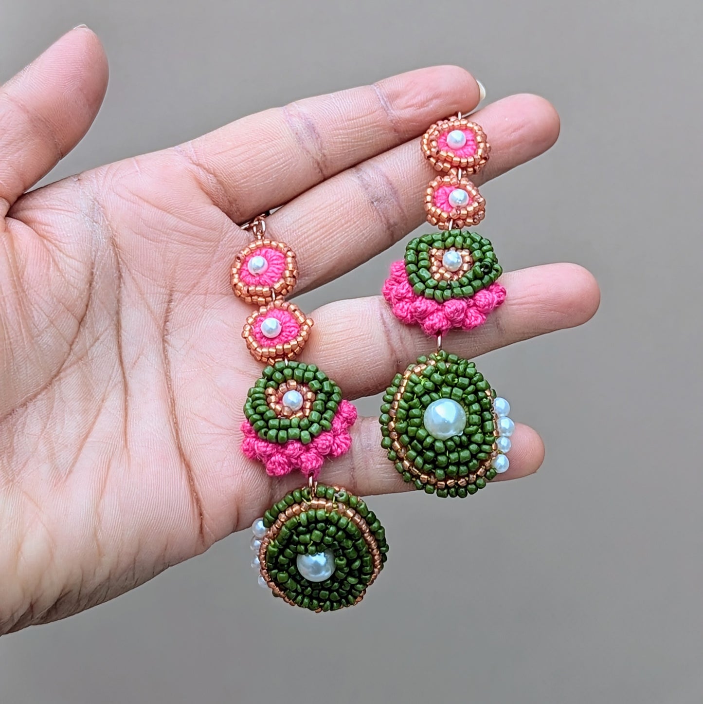 Minna artisan beaded earrings held in hand to show scale, lightweight design, and flowing form, handmade in the UK by Mayaani Jewellery.