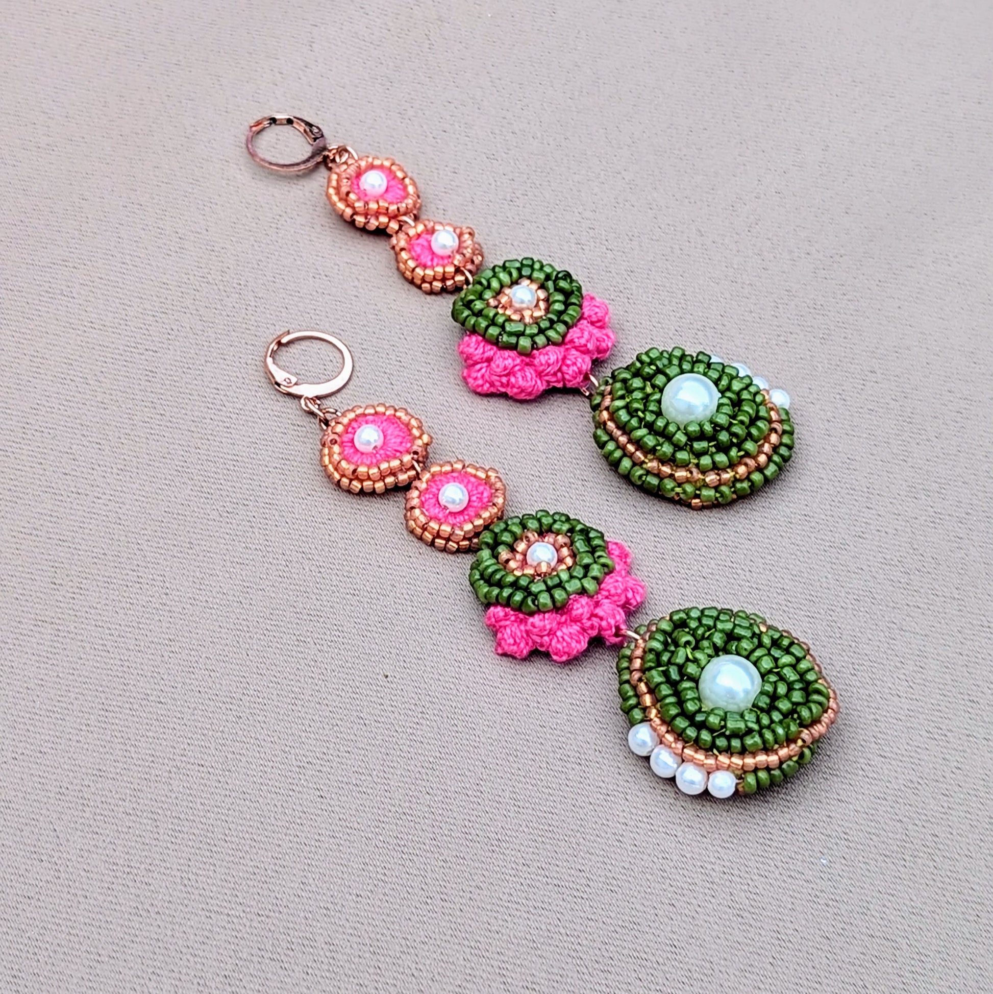 Side view flat lay of Minna beaded statement earrings showing layered beadwork, crochet texture, and rose gold accents on a soft neutral background.