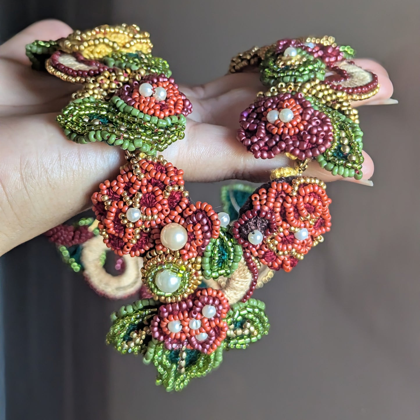 Handmade botanical statement necklace by Mayaani Jewellery - close up showing detachable front pendant clasp in burgundy and gold beadwork.
