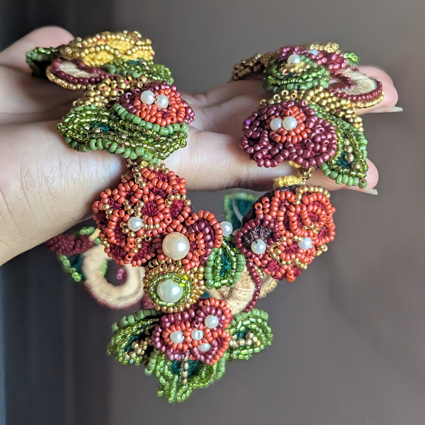 Hand held view of the Rukmini 2-in-1 artisan handmade couture neckpiece exclusive to Mayaani UK featuring innovative front facing detachable pendant clasp for sustainable luxury which flows from occasion to everyday.