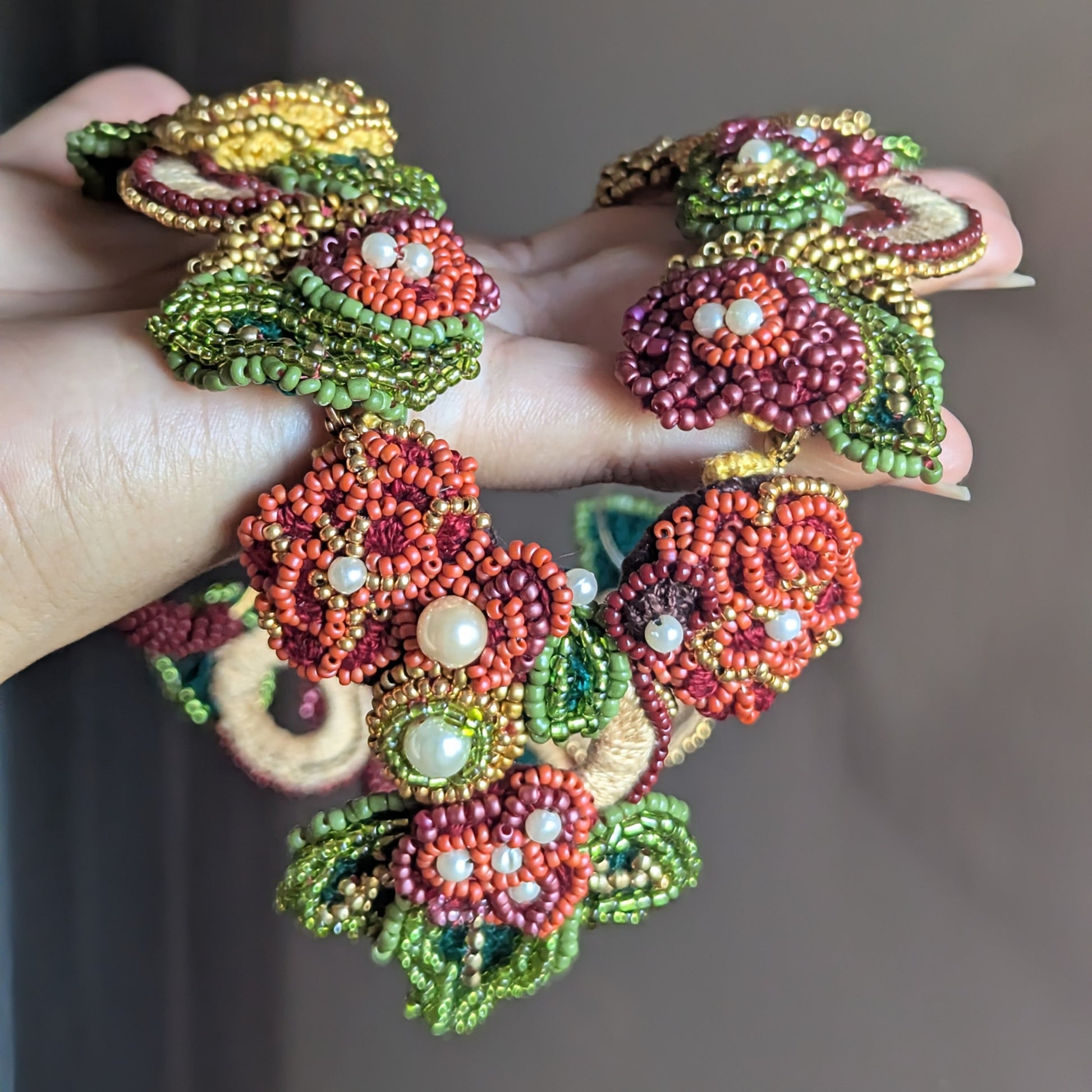 Hand held view of the Rukmini 2-in-1 artisan handmade couture neckpiece exclusive to Mayaani UK featuring innovative front facing detachable pendant clasp for sustainable luxury which flows from occasion to everyday.