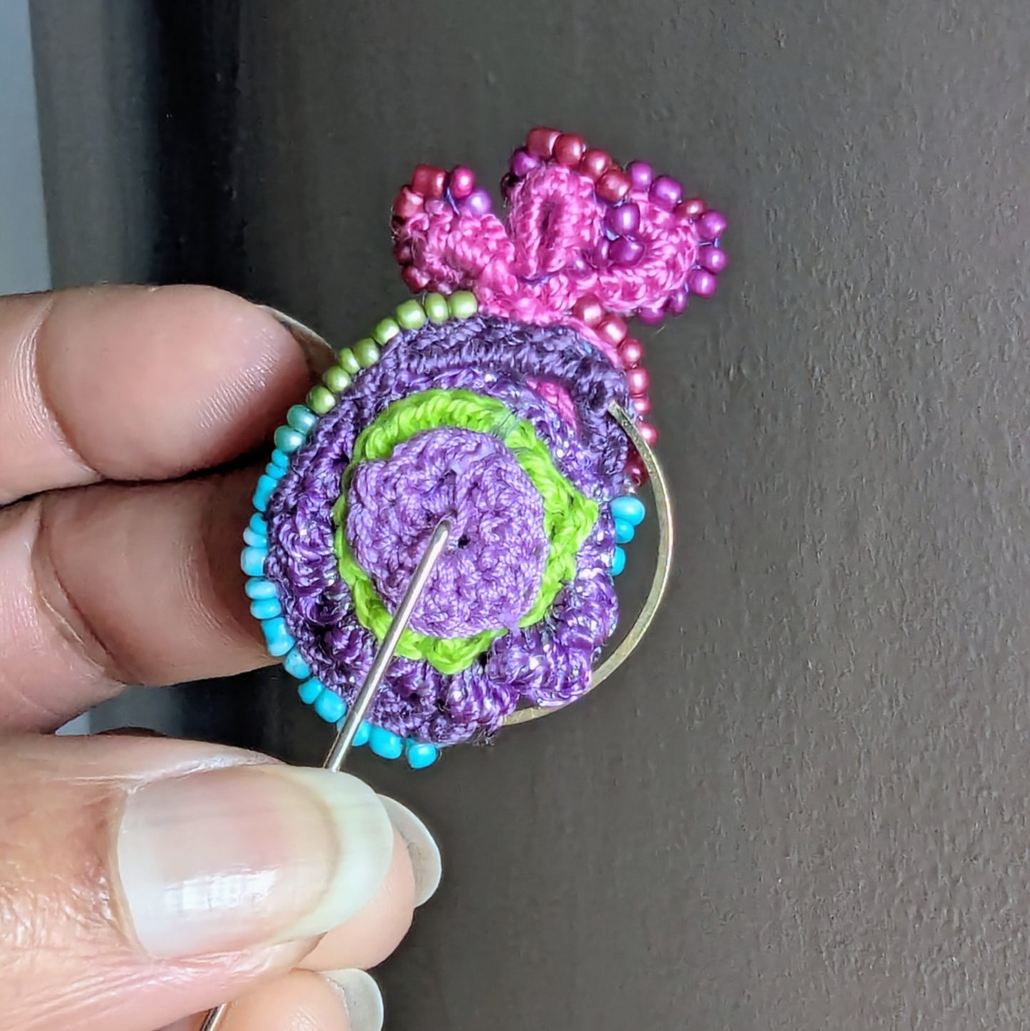 Back view of Navira handmade brooch showing secure stainless steel pin fastening and structured textile beadwork construction.
