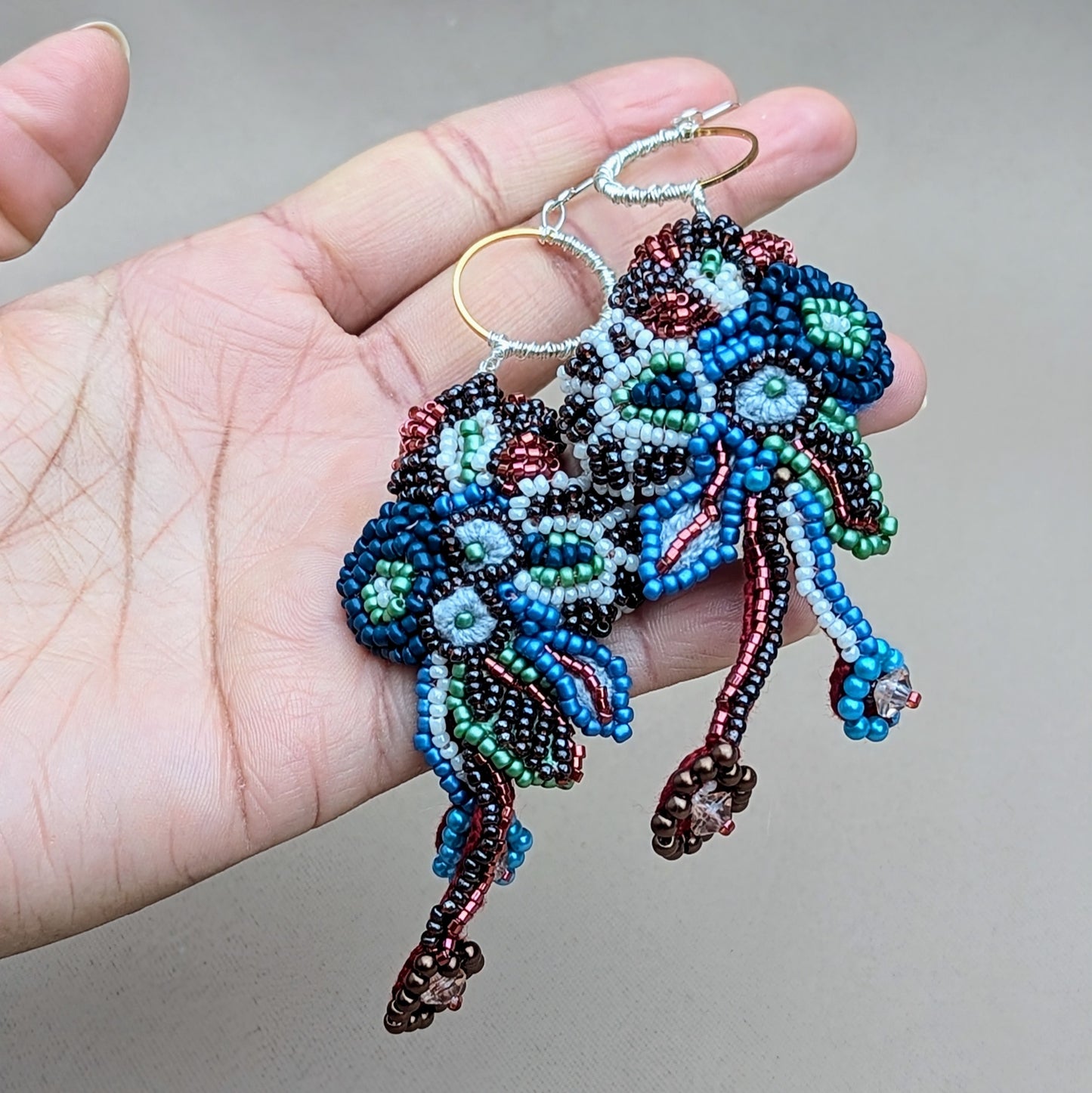 Handmade Neelara statement earrings by Mayaani Jewellery, showcasing cascading, red, blue and white bead embroidery with hand crochet and wire wrapping, designed for expressive, artistic wear.