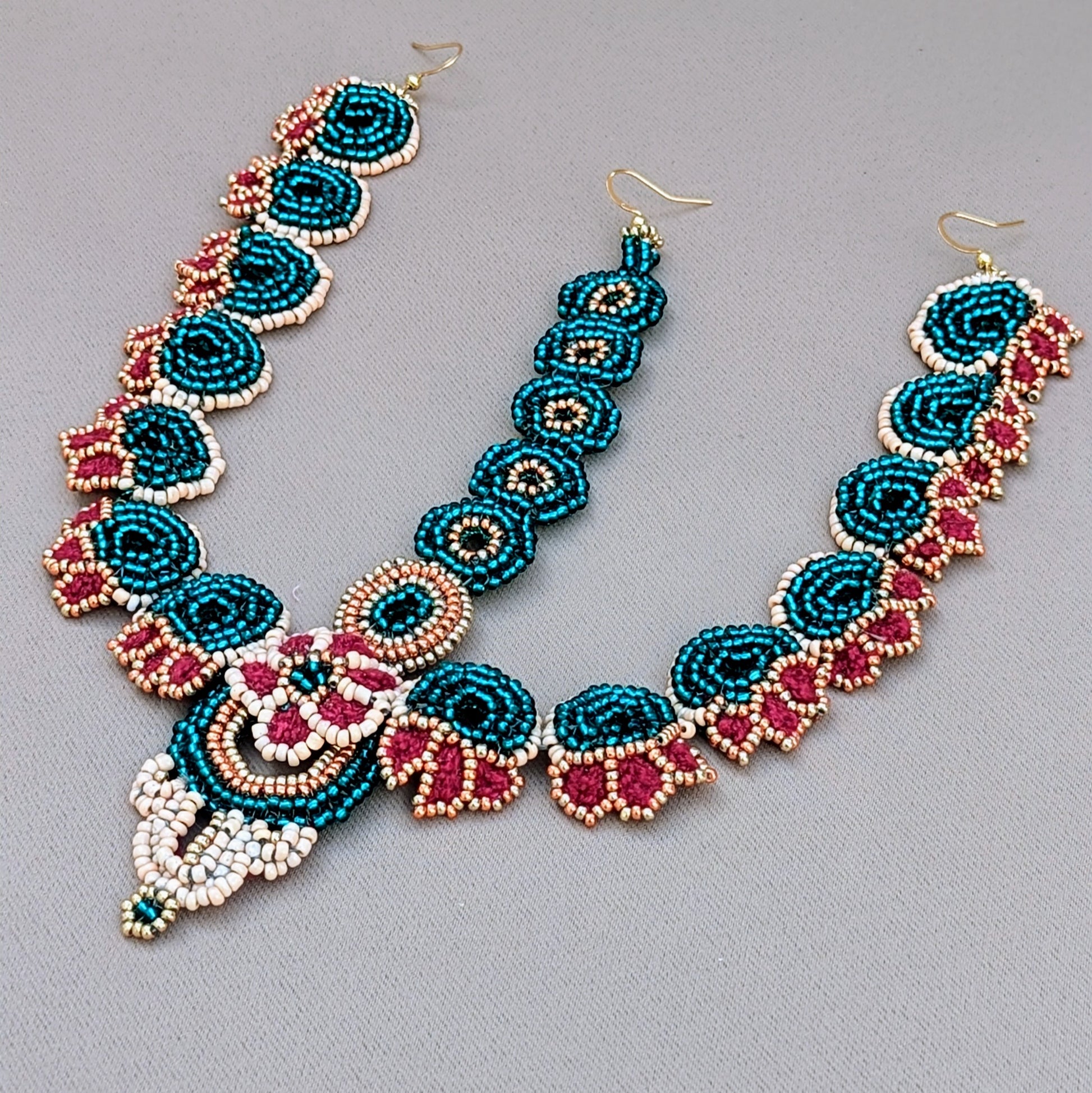 One-of-a-kind Indian bridal headpiece with matching earrings, hand-beaded in emerald green, red, soft peach, and shimmering gold, finished with crochet and wirework by Mayaani Jewellery.