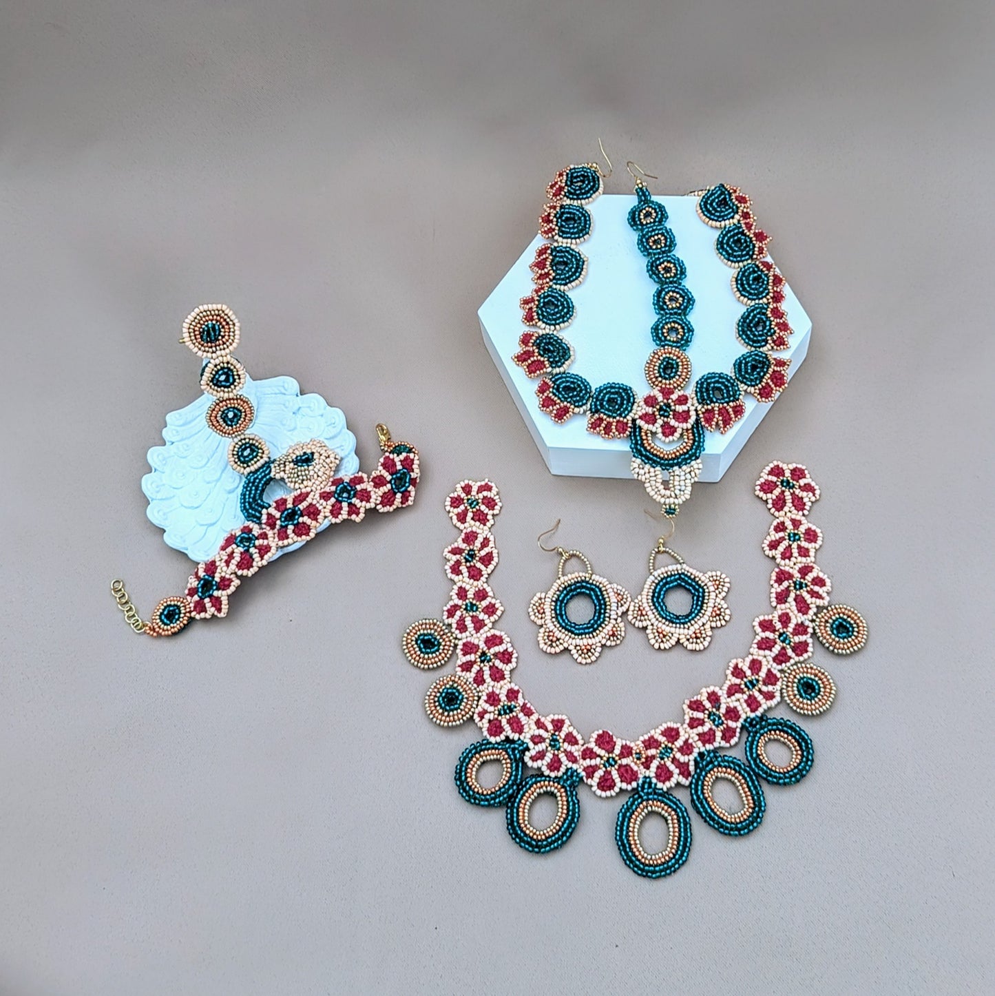 Mayaani Jewellery UK Neha Collection bridal set in emerald green, red, gold and peach featuring a meticulously handcrafted necklace, pair of earrings, headpiece and hand bracelet.