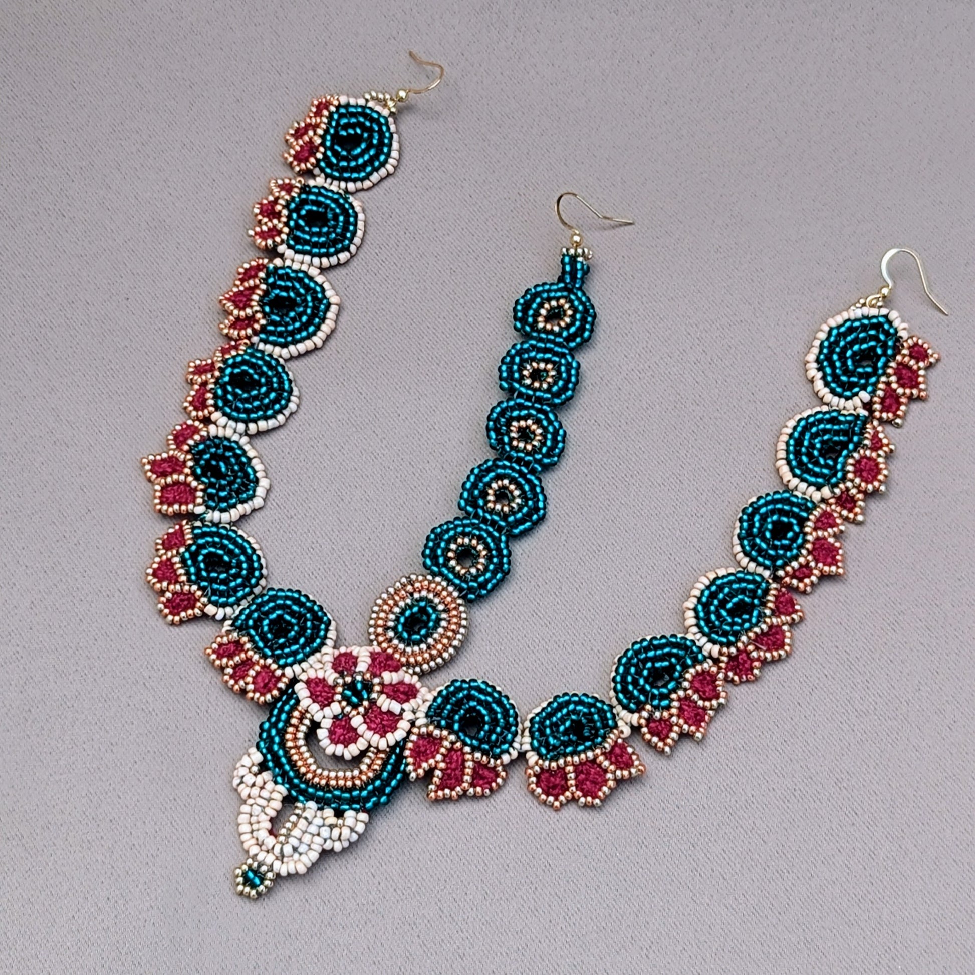 Handcrafted maang tikka bridal set in emerald green, red, and gold tones, designed with floral beadwork and intricate wire wrapping, part of the Neha Collection by Mayaani Jewellery UK.