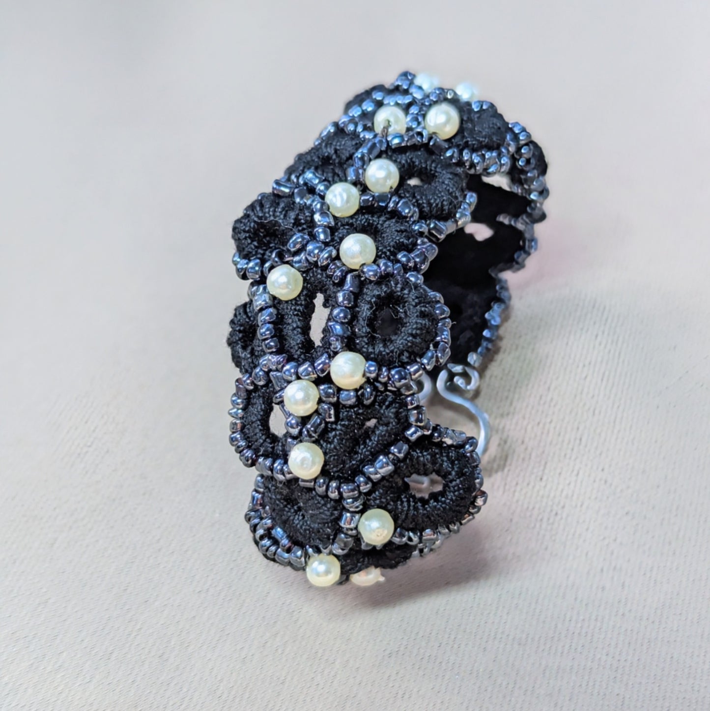 Detail view of the Nisha handmade crochet bracelet with pearl accents on a clean backdrop.