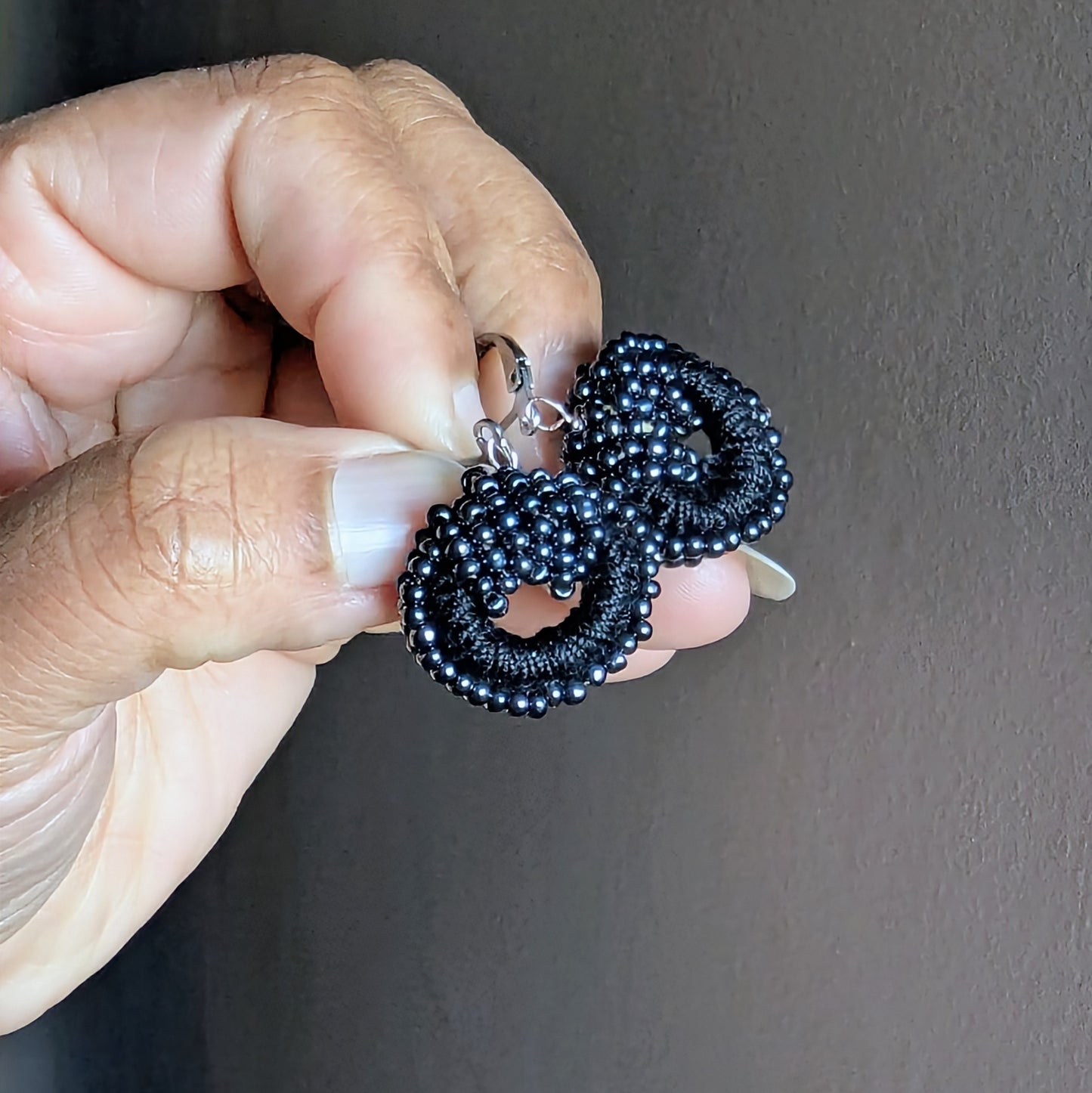 Close-up of sustainable black and pearl beaded earrings crafted by Mayaani Jewellery.