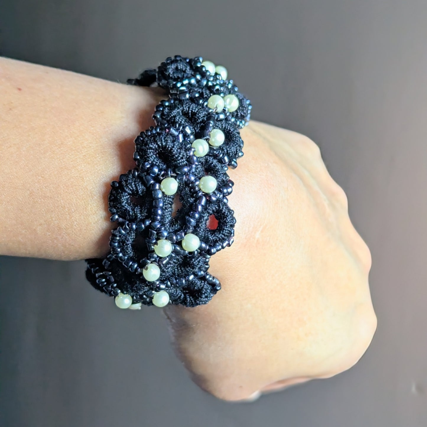 Nisha black crochet bracelet displayed on the wrist, highlighting the continuous woven design and soft beaded edges.
