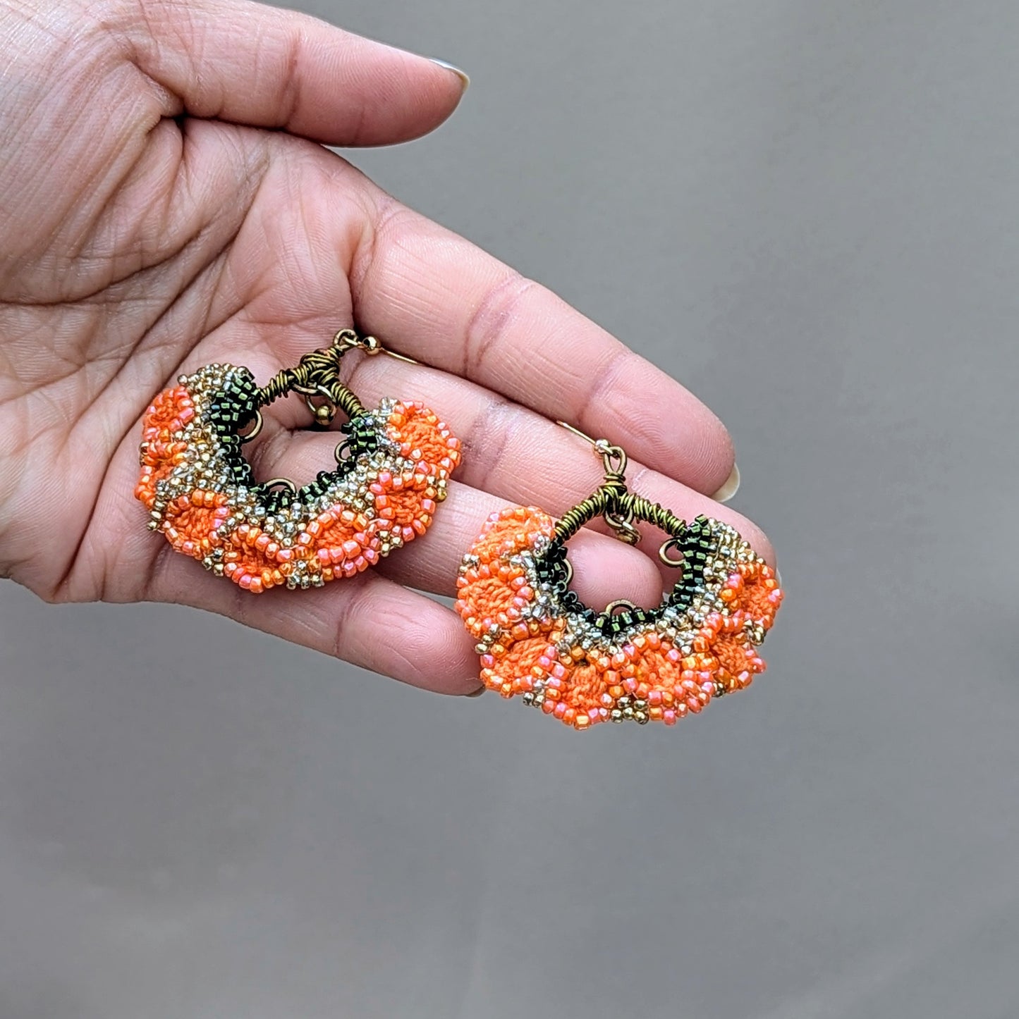 Vibrant orange Indian jhumka earrings with seed bead details, sustainable design, and hypoallergenic gold-plated stainless steel hooks.