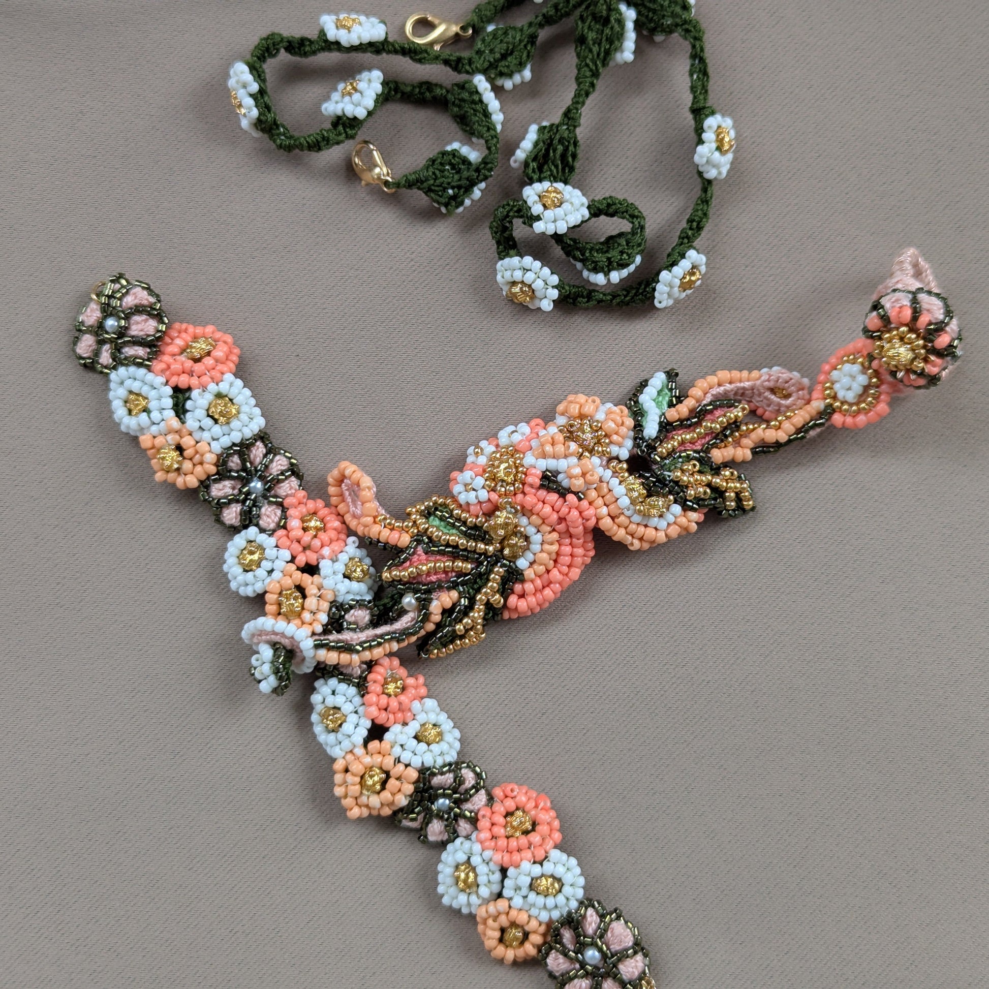 Flat lay view of the Padmika 5-in-1 couture bead crochet versatile Indian hand bracelet with custom chain in peach, green and white with vintage gold bead accents. Made in the UK by Mayaani.