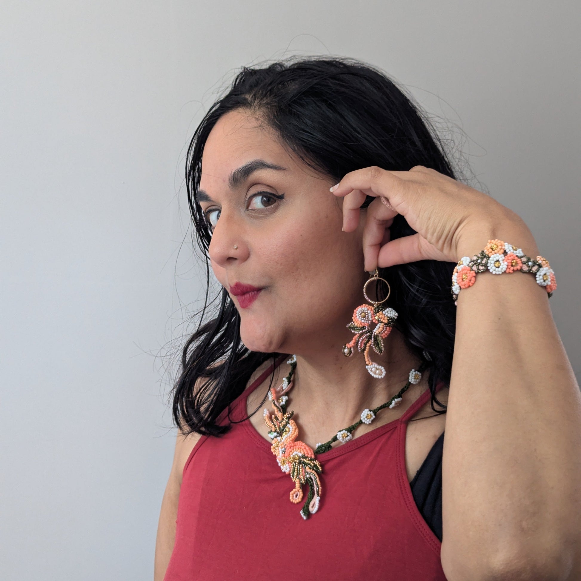 Indian UK designer and artisan Megha of Mayaani wearing the Padmika 5-in-1 Indian bracelet elements while holding the matching earring against her ear.