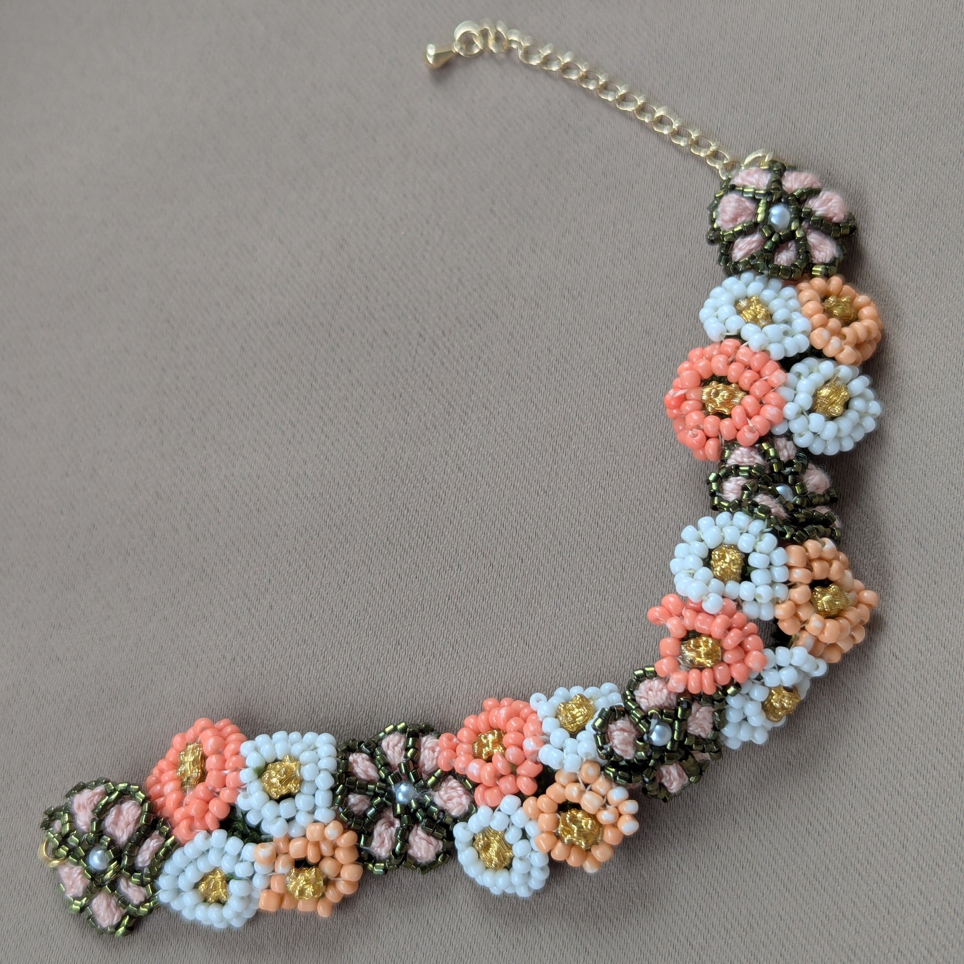 The handmade Padmika 5-in-1 wrist bracelet element in peach, green and white featuring gold accents. Fusion wear for the diaspora Indian woman.