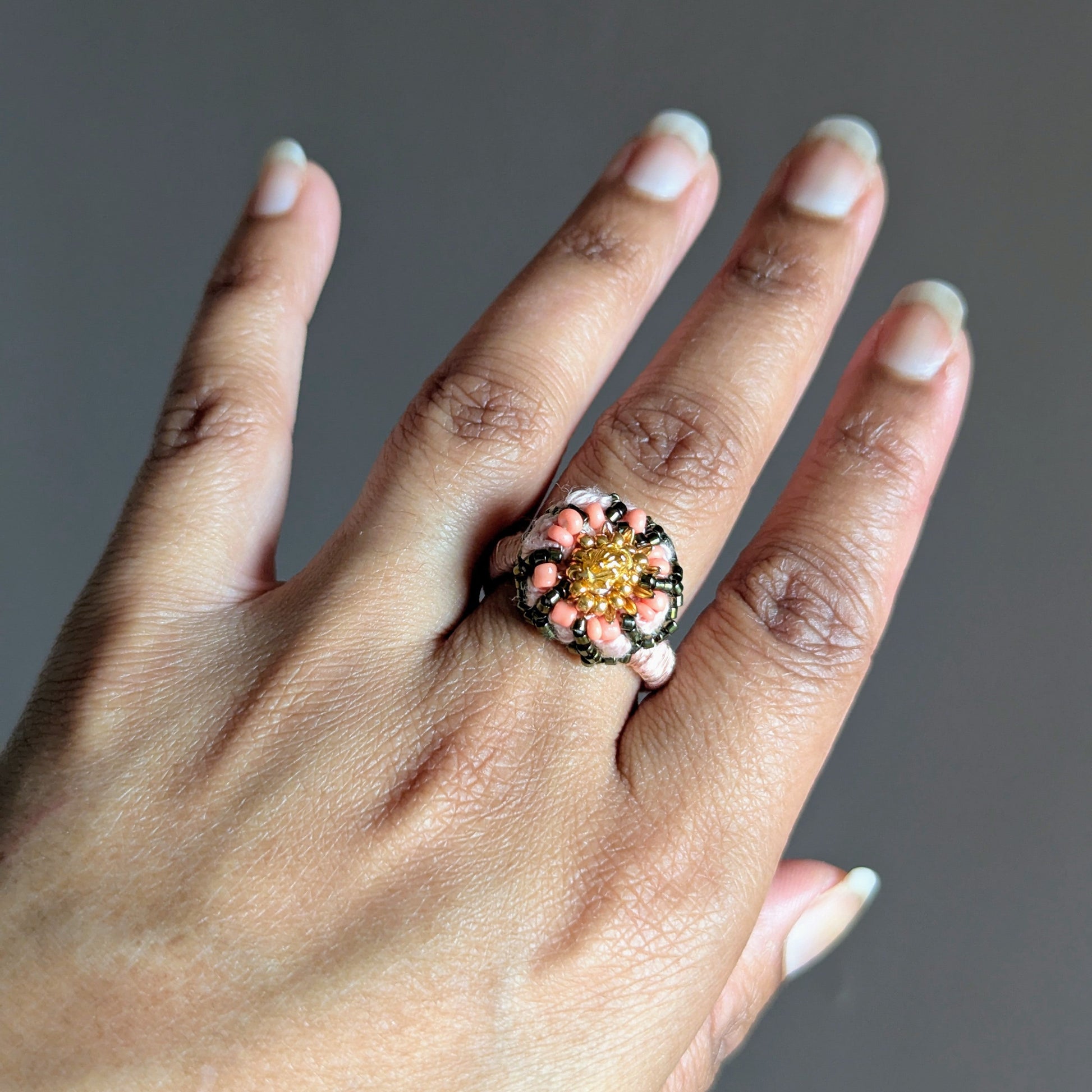 Close up of a hand wearing the Padmika 5-in-1 Indian statement ring element handcrafted in the UK using crochet and bead embroidery techniques.
