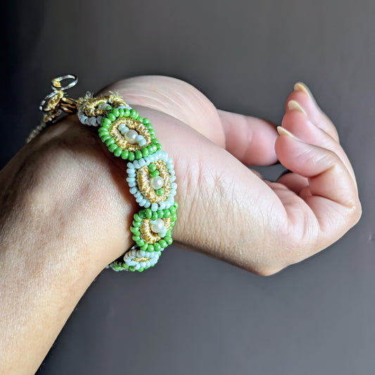 Artisan-made green beaded bracelet featuring handwoven motifs, triple-mercerised cotton, and a gold-plated clasp.