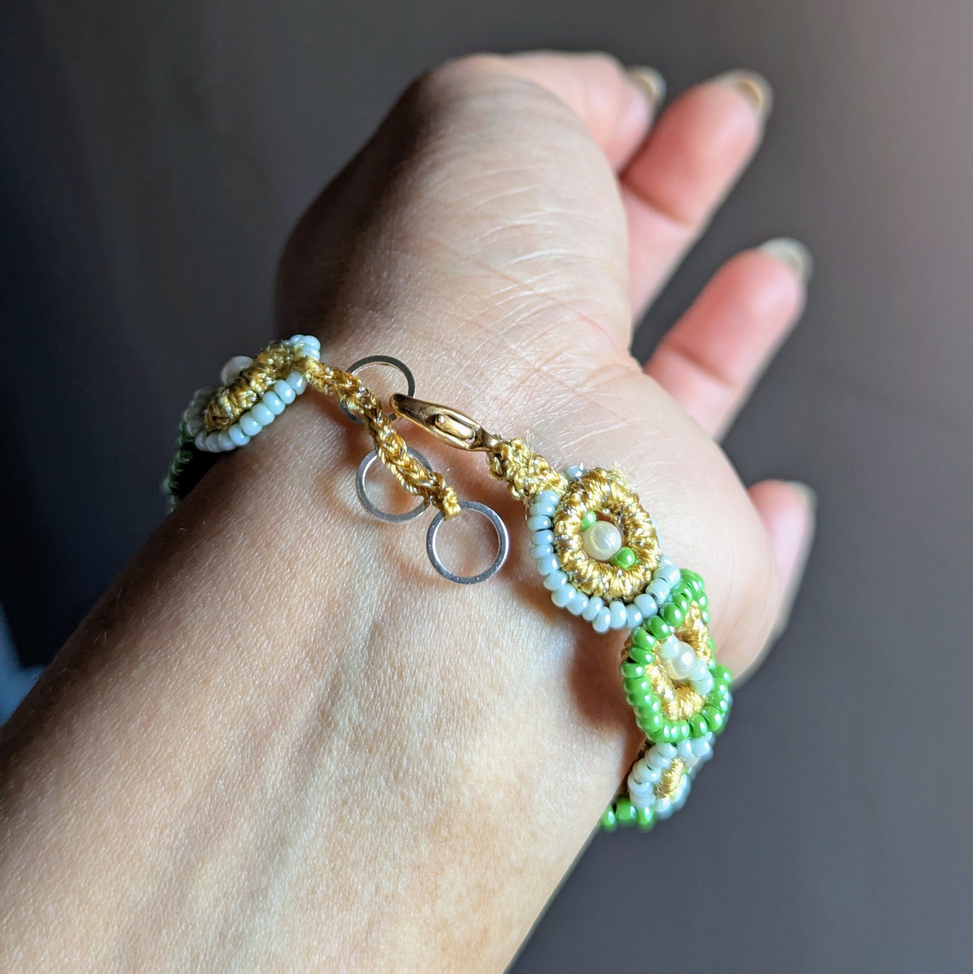 Handwoven green and pearl beaded bracelet crafted with Czech beads, vintage pearls, and gold accents by Mayaani Jewellery.
