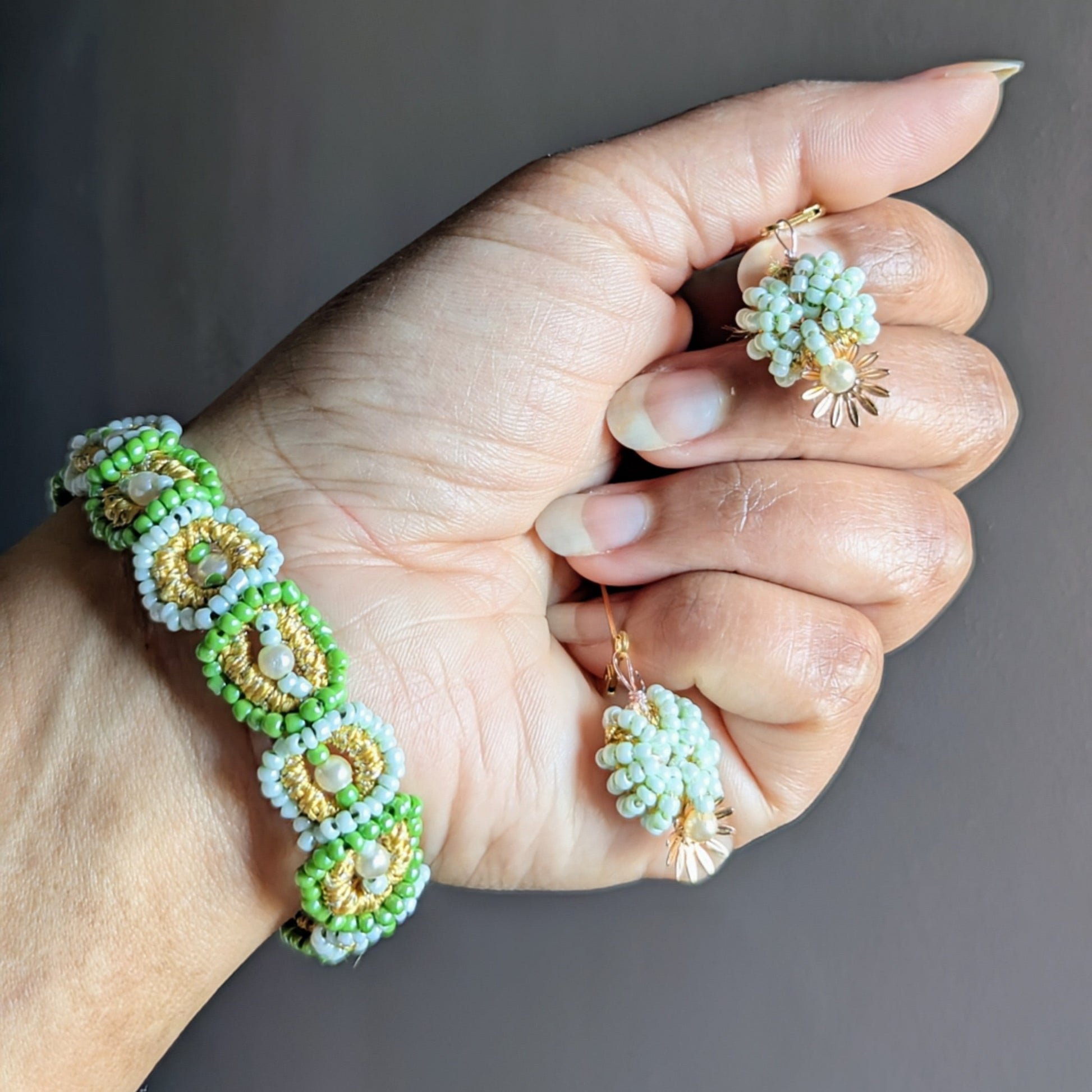 “Matching green and pearl beaded Indian jewellery set—bracelet and earrings—displayed on a hand, handcrafted by Mayaani Jewellery.”
