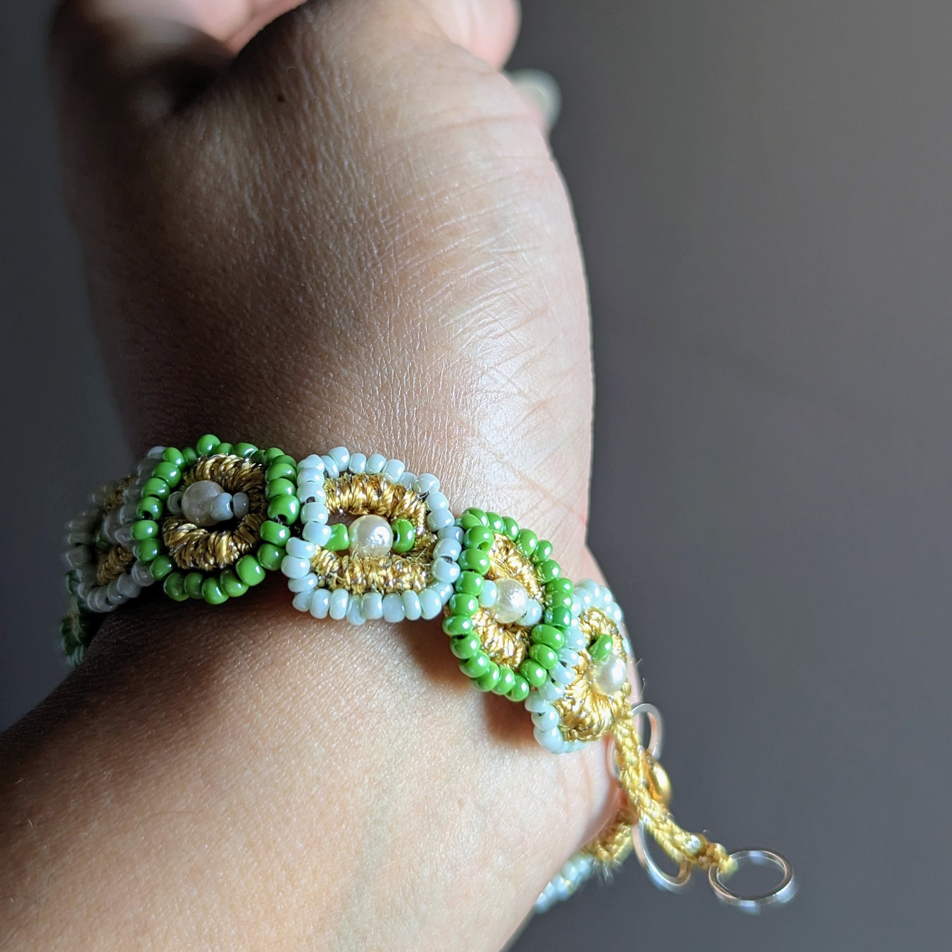 Artisan beaded bracelet in green and ivory tones with gold clasp, handmade in the UK by Mayaani Jewellery.