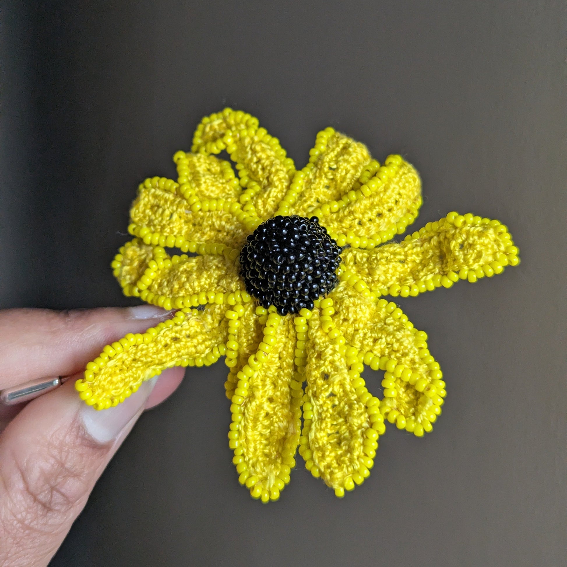Vamika brooch held and slightly turned - showing petal depth and texture.