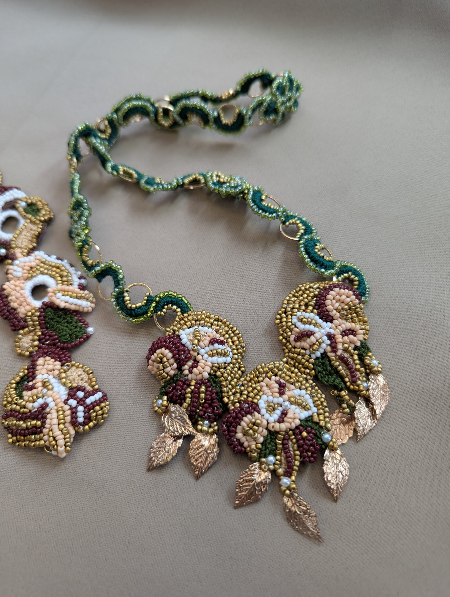 Intricate bead woven Rukmini emerald green and gold chain exclusive to Mayaani Jewellery UK featured with the central detachable pendant of the Aishwarya 2-in-1 Indian bridal necklace.