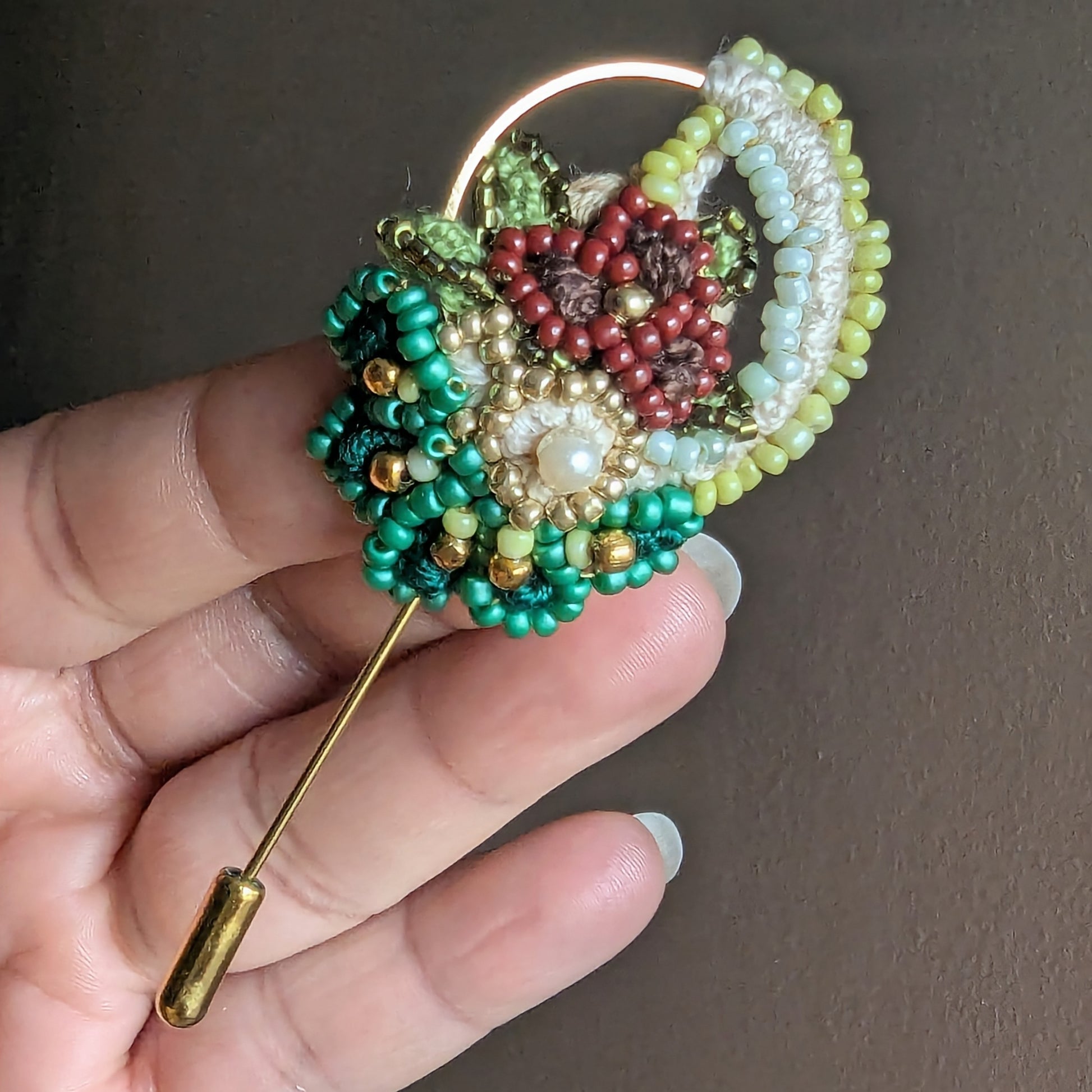 Detailed view of Sarika handcrafted brooch highlighting green Miyuki seed beads and vintage seed pearl.