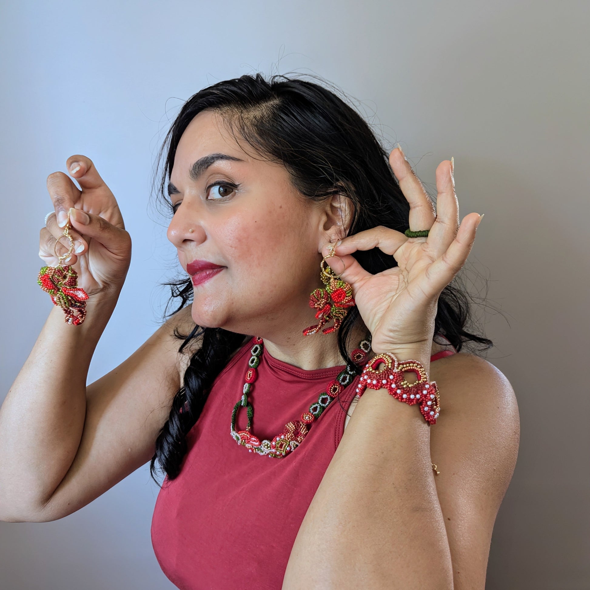 Mayaani Jewellery designer and artisan Megha modelling the Shreya 5-in-1 ring, bracelet and necklace elements - which connect to form one statement Indian hand bracelet - while holding the matching Shreya earrings against her ear.