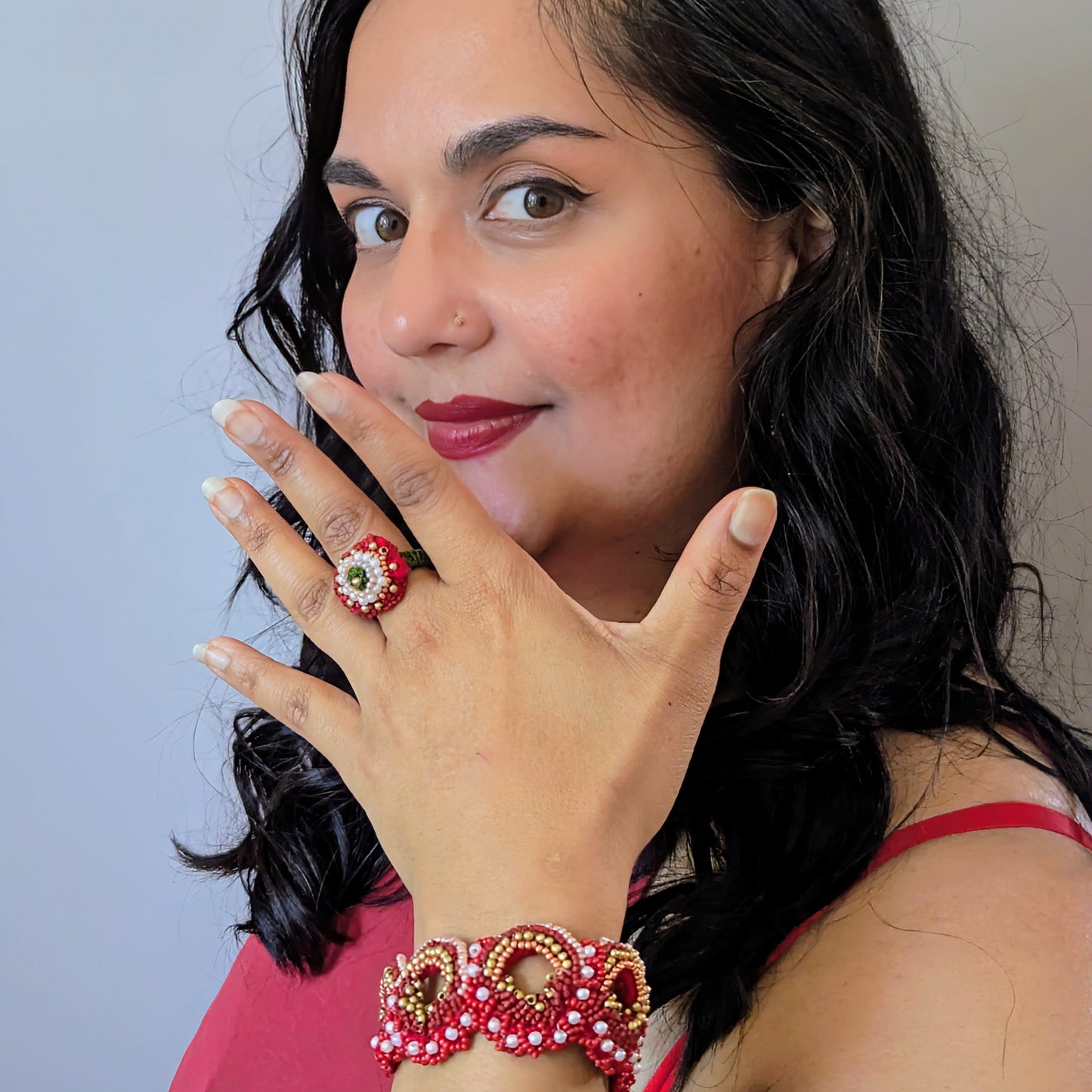 Close up view of the Shreya cocktail ring and statement wrist bracelet elements modelled by Megha of Mayaani UK against a neutral backdrop.